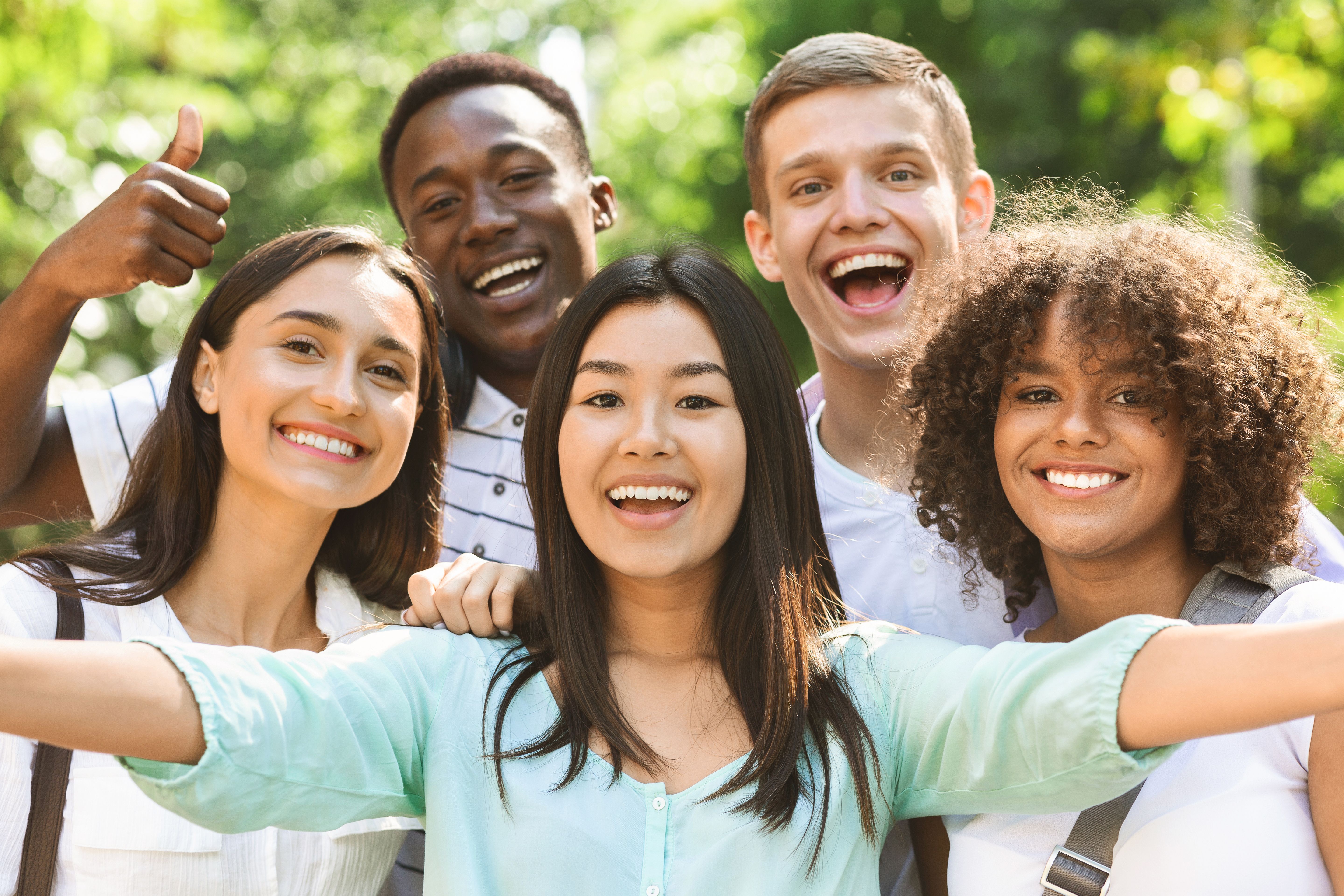 Group of multi-ethnic teen friends taking selfie picture outdoors Group of multi-ethnic teen friends taking selfie picture outdoors