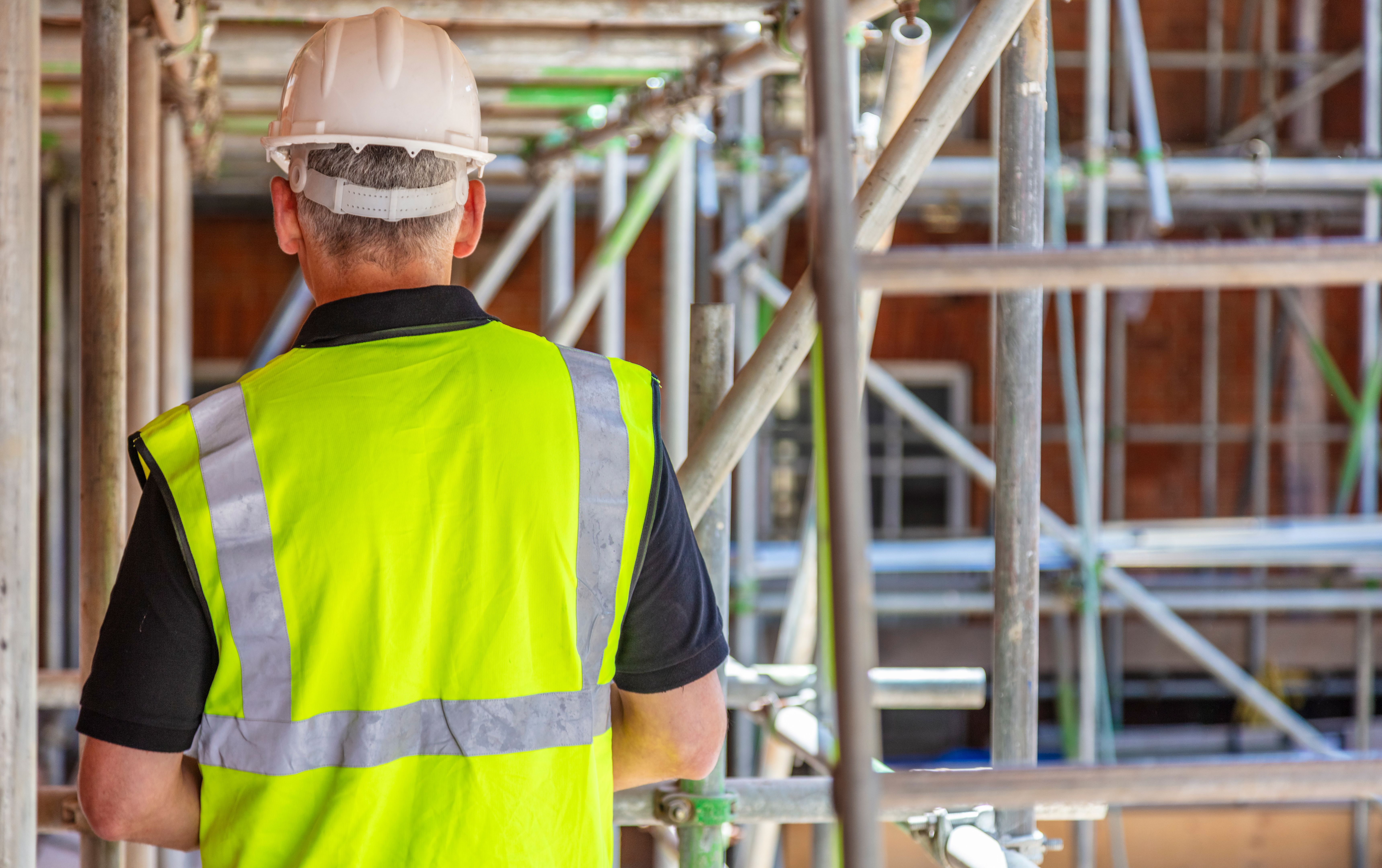 Rear View of a Construction Worker on Building Site
