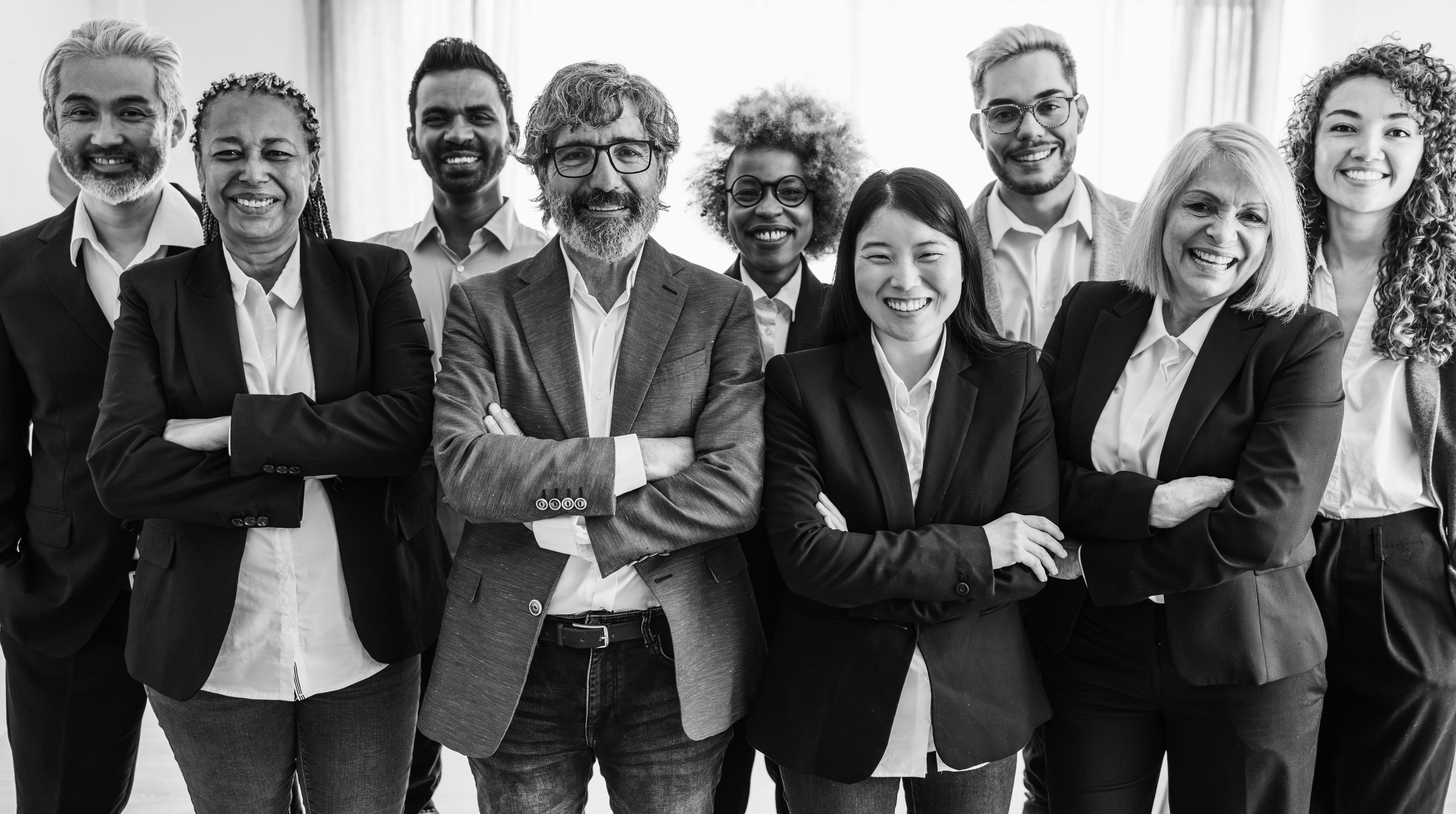 Multi generational workers smiling in front of camera inside business office - Multiracial entrepreneur and teamwork concept - Main focus on man with glasses - lack and white editing Multi generational workers smiling in front of camera inside business office - Multiracial entrepreneur and teamwork concept - Main focus on man with glasses - lack and white editing