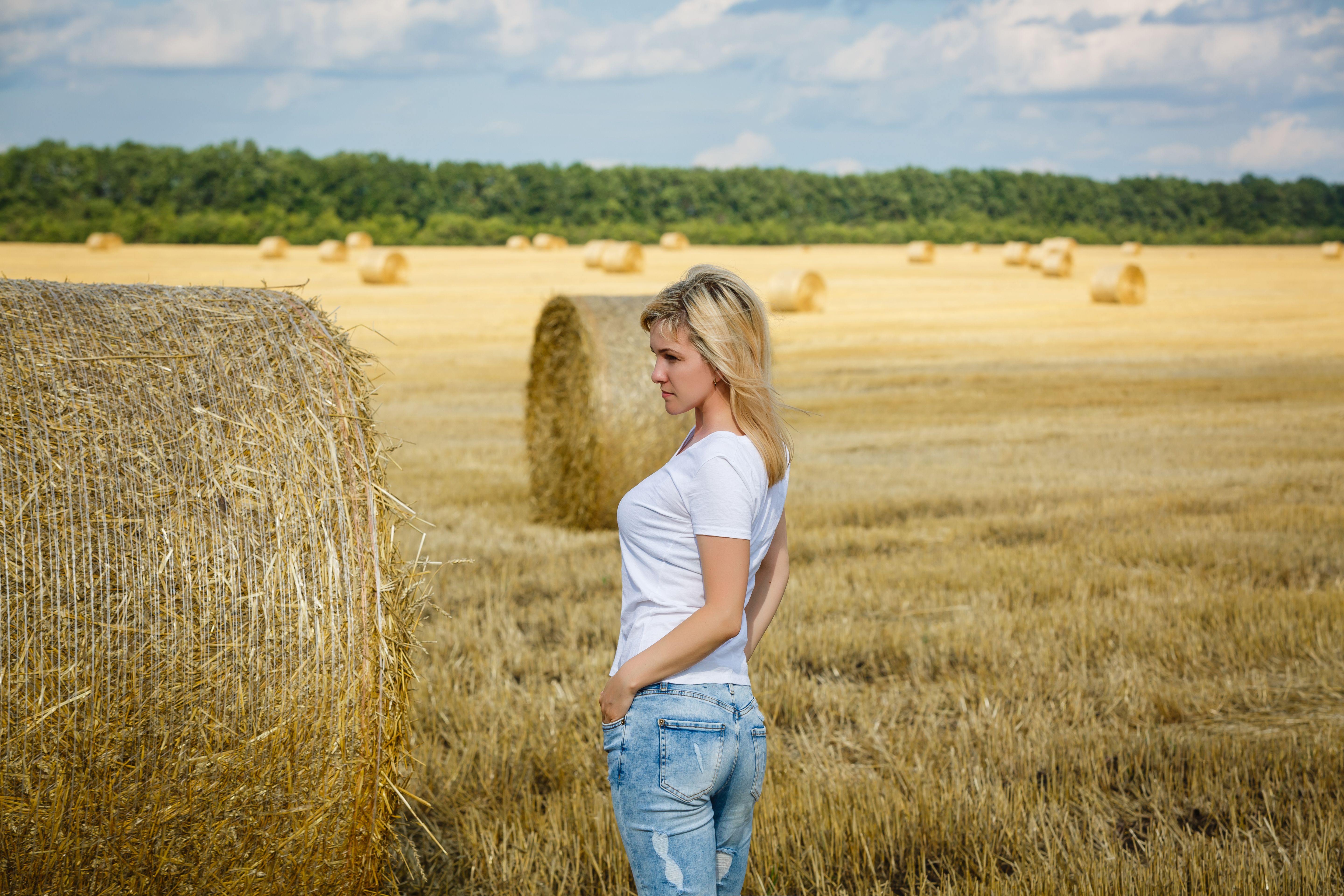 Attractive young woman near the stacks of straw