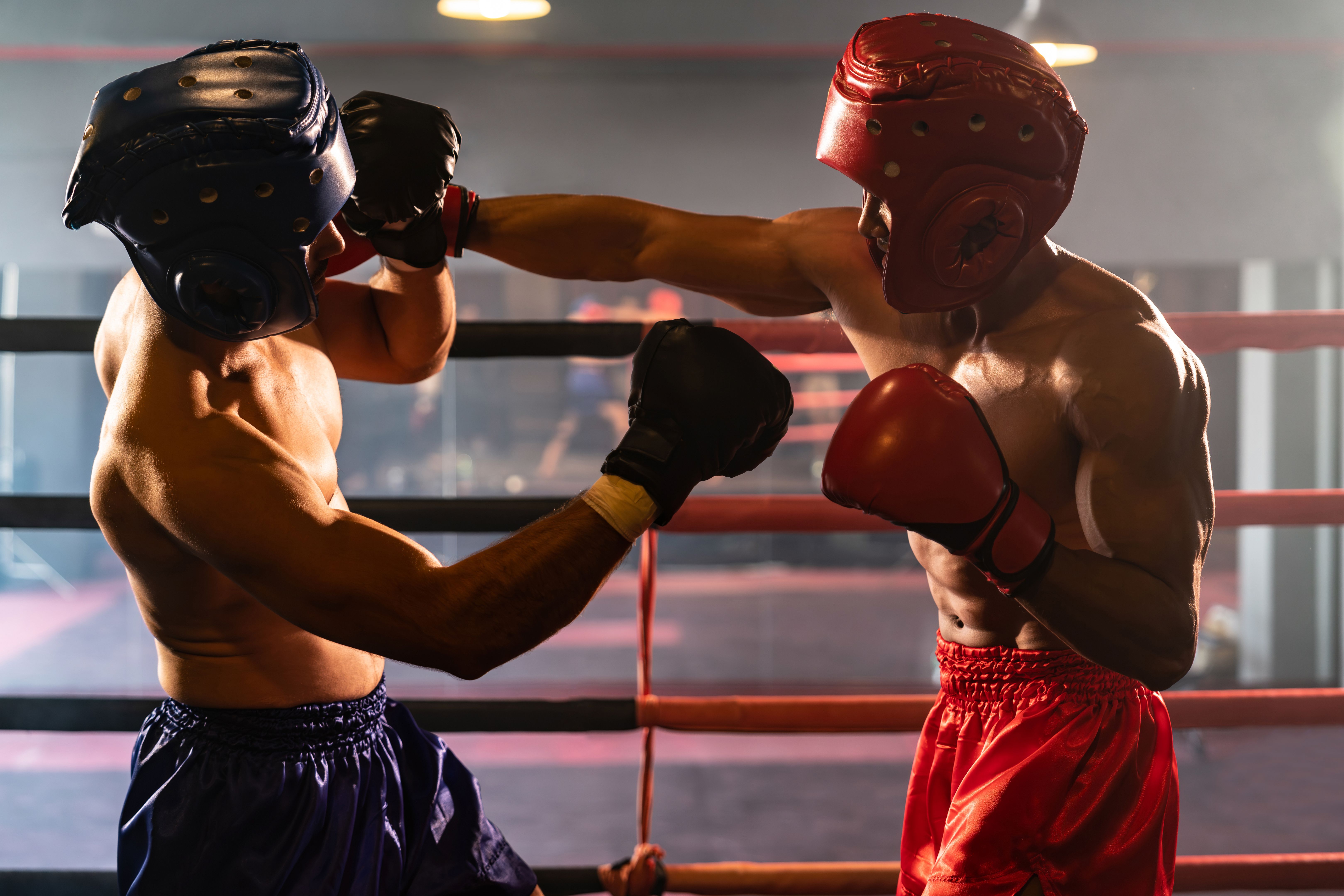 Dois pugilistas atléticos e musculosos com capacete de segurança em luta de boxe. Impulso Dois pugilistas atléticos e musculosos com capacete de segurança em luta de boxe. Impulso