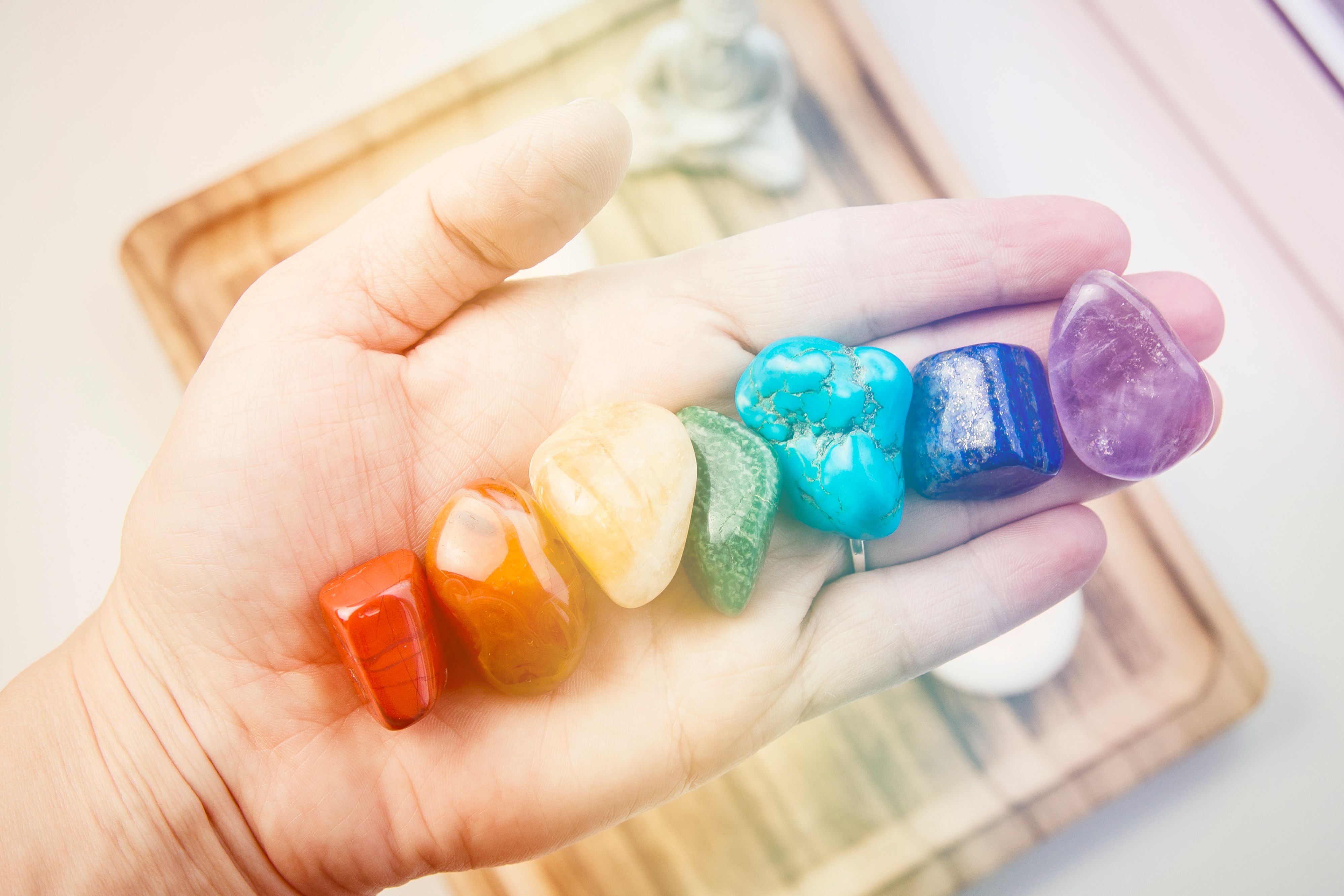Woman hand sowing all seven color chakra crystal stones. Chakra energy flow healer concept. Woman hand sowing all seven color chakra crystal stones. Chakra energy flow healer concept.