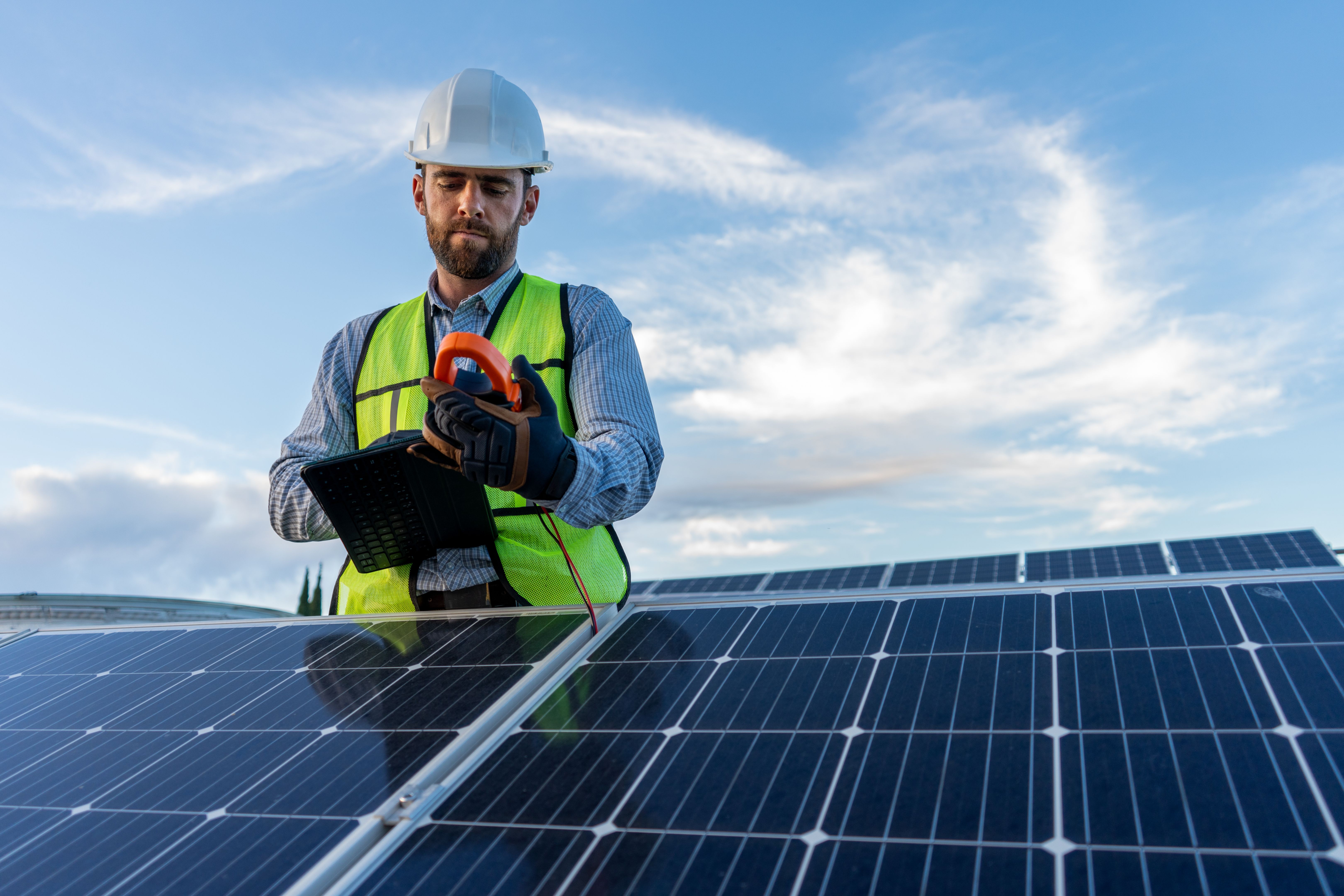 engineer technician checking output voltage level of inverter, electrician measuring power on solar panels