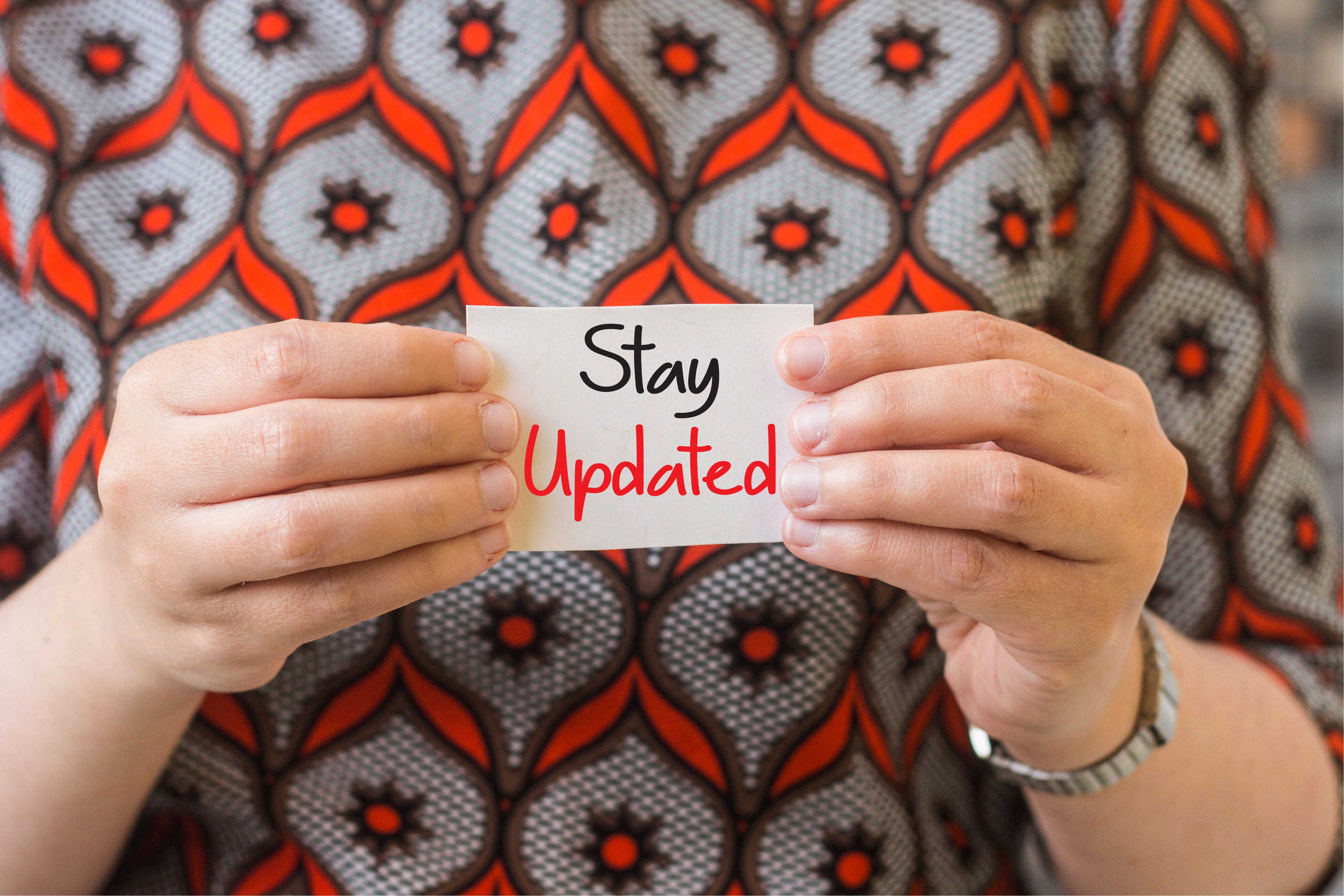 businesswoman holding card with text, Stay Updated