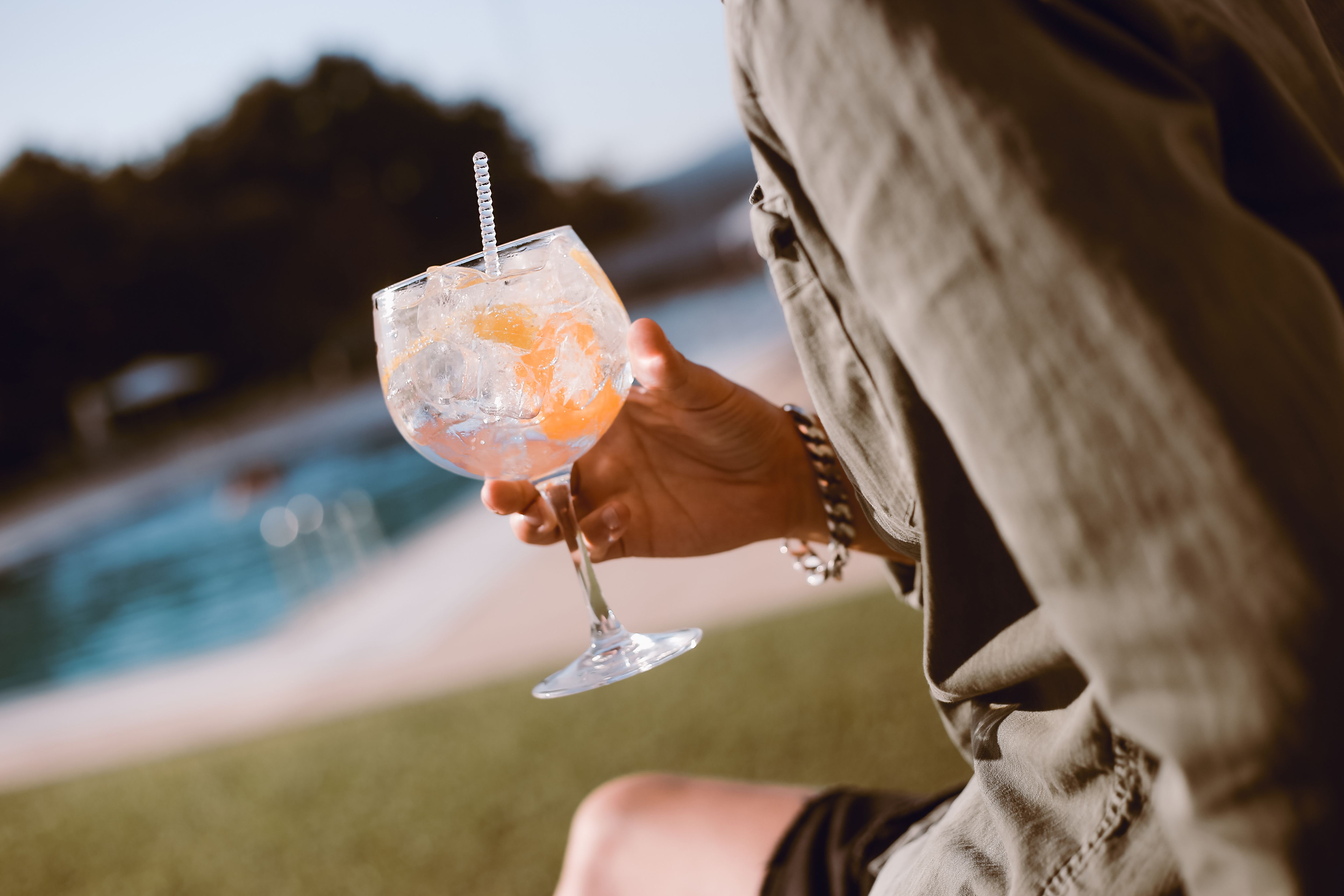 Man drinking cocktail near the pool