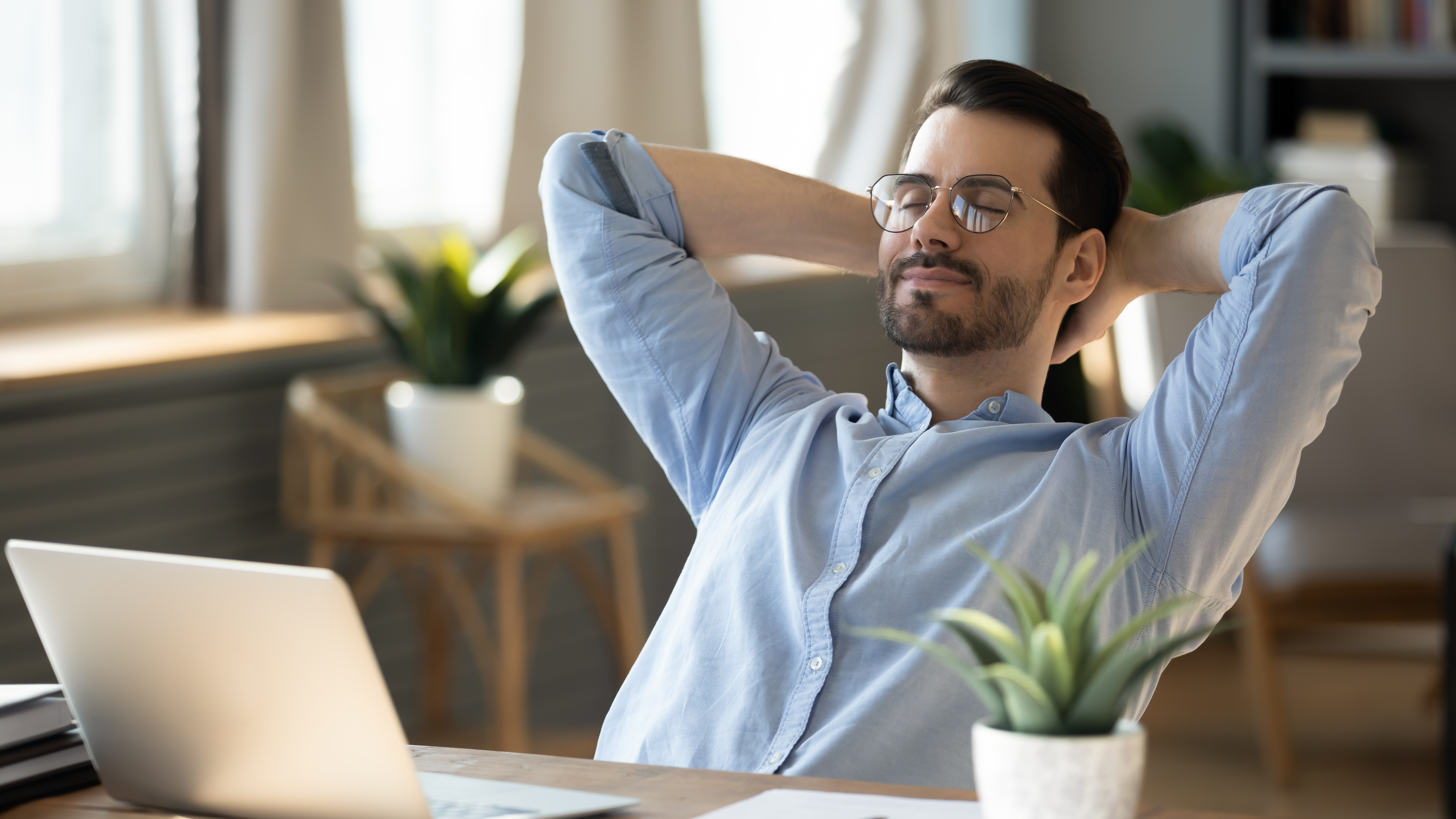 Jeune homme calme se détendre dans la chaise au lieu de travail à la maison Jeune homme calme se détendre dans la chaise au lieu de travail à la maison