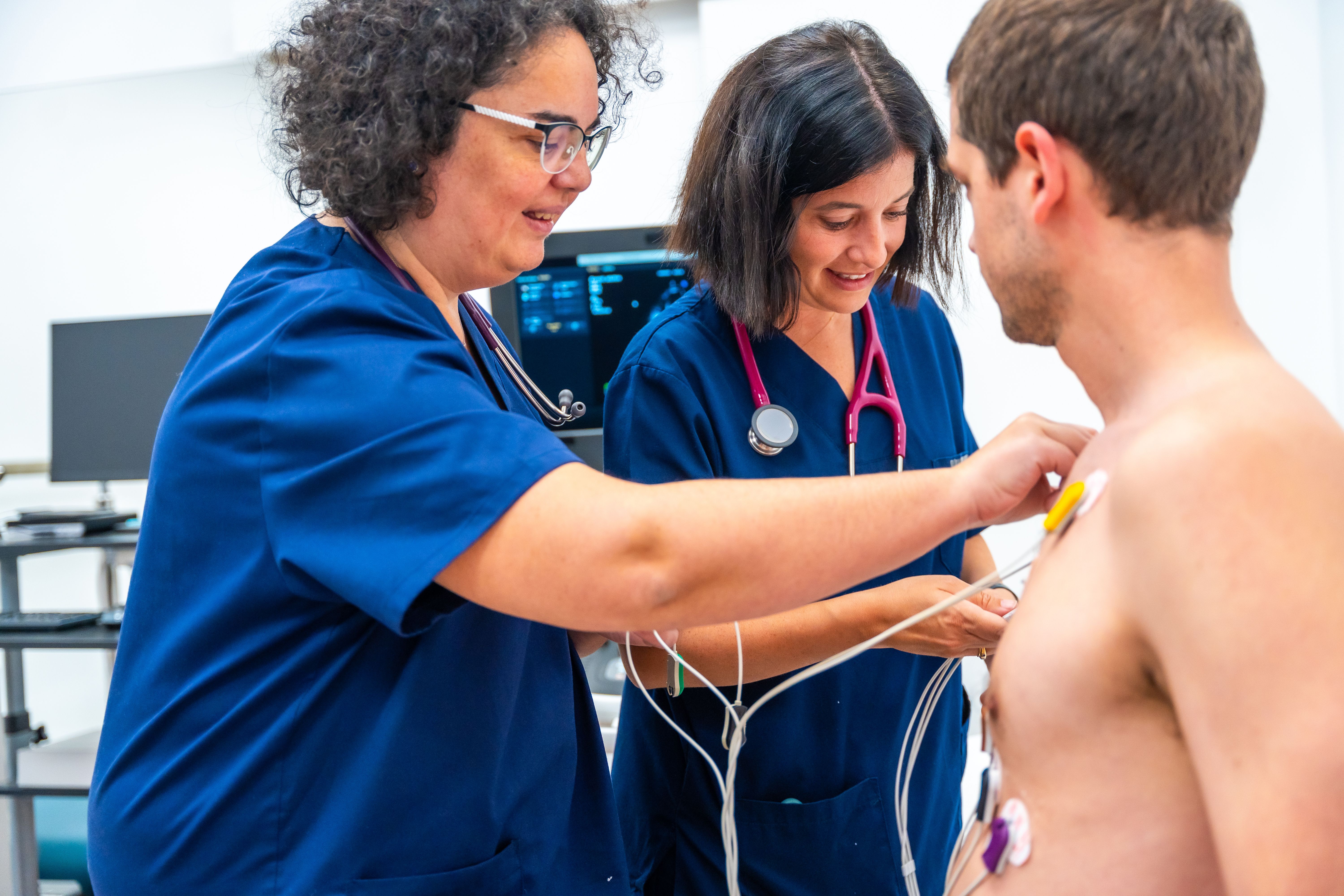 Cardiólogo colocando los electrodos en un paciente para realizar una prueba de esfuerzo cardiovascular