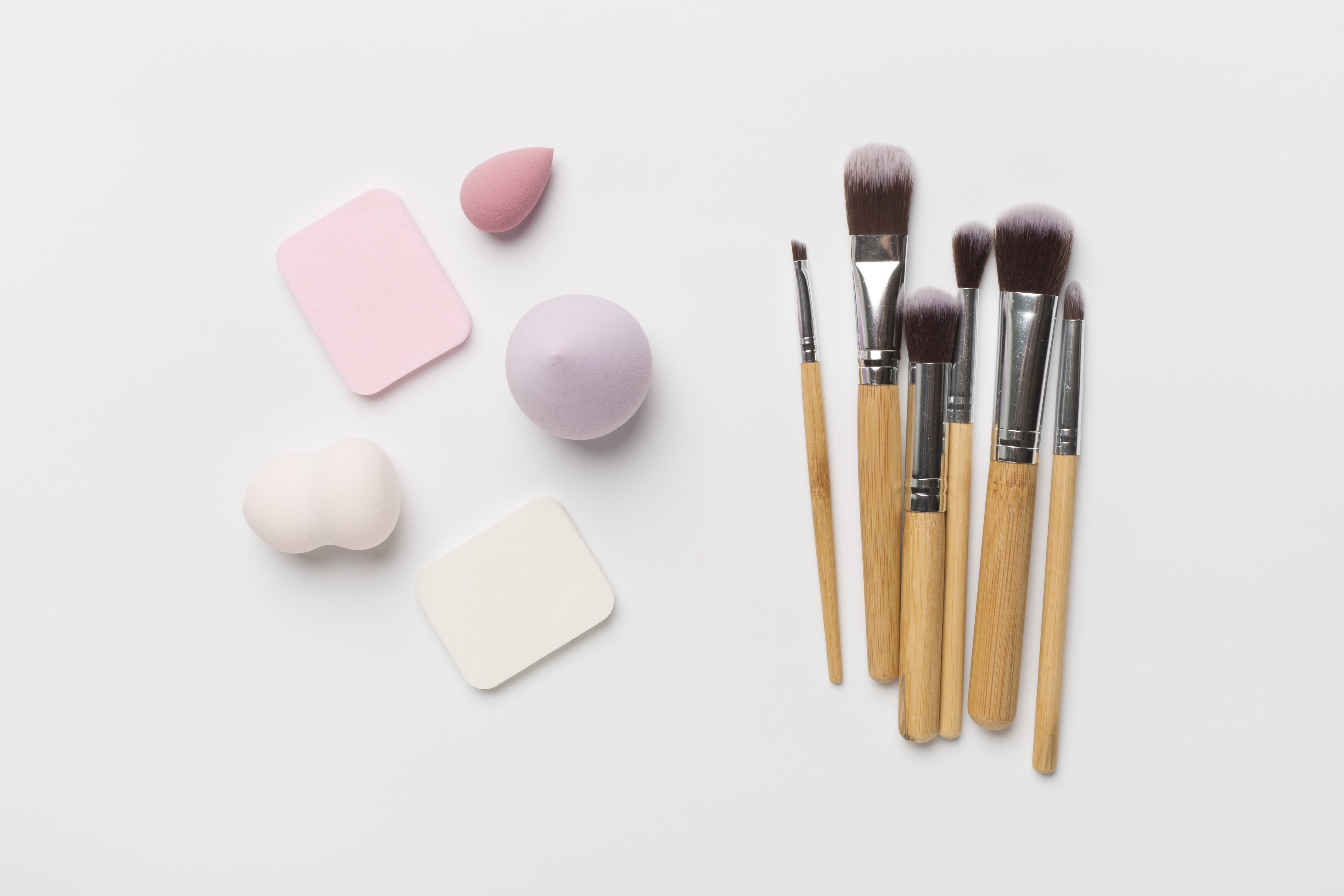 Make up brush and sponge on color background, top view Make up brush and sponge on color background, top view