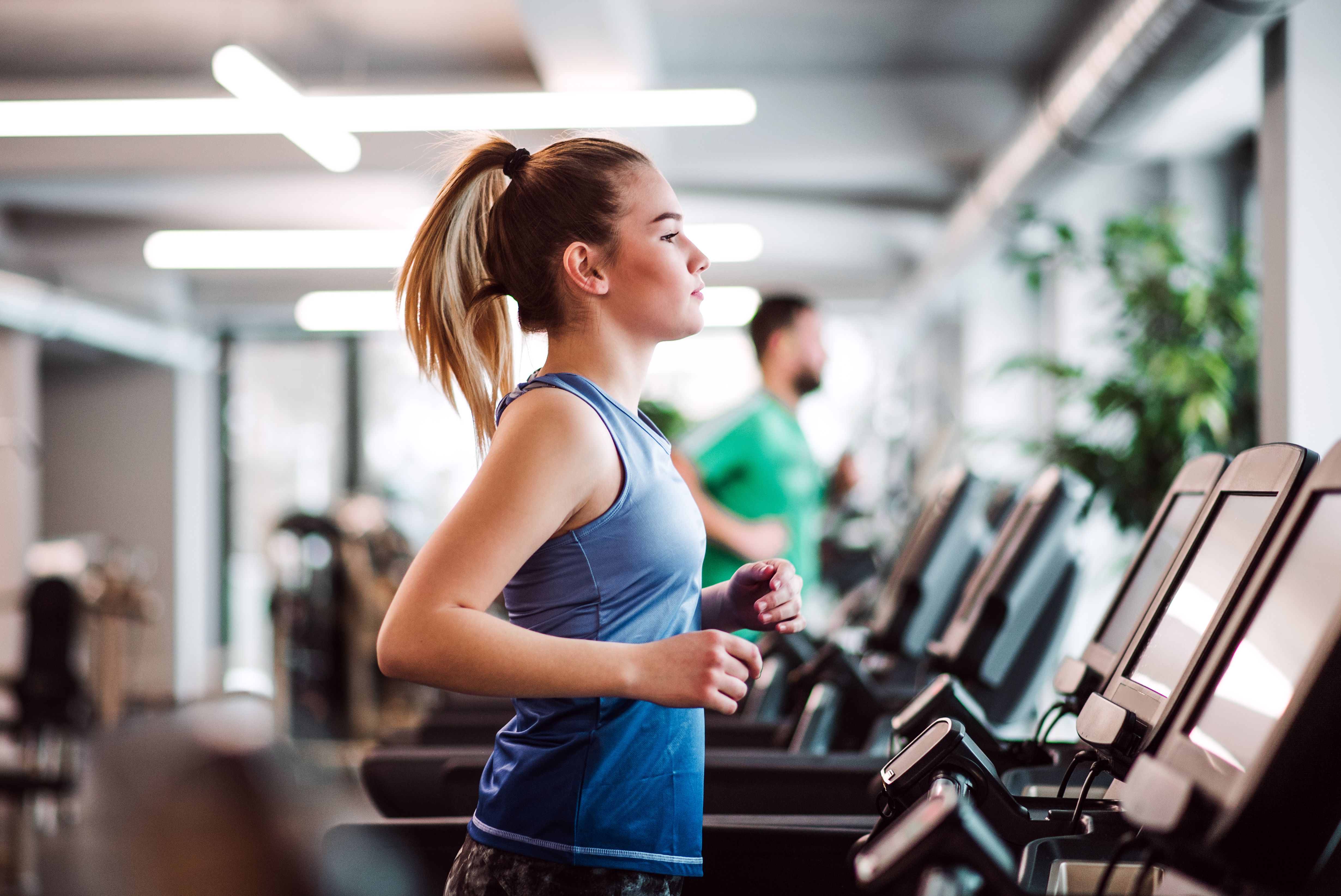 Un retrato de una chica joven o una mujer haciendo ejercicio cardiovascular en un gimnasio. Un retrato de una chica joven o una mujer haciendo ejercicio cardiovascular en un gimnasio.