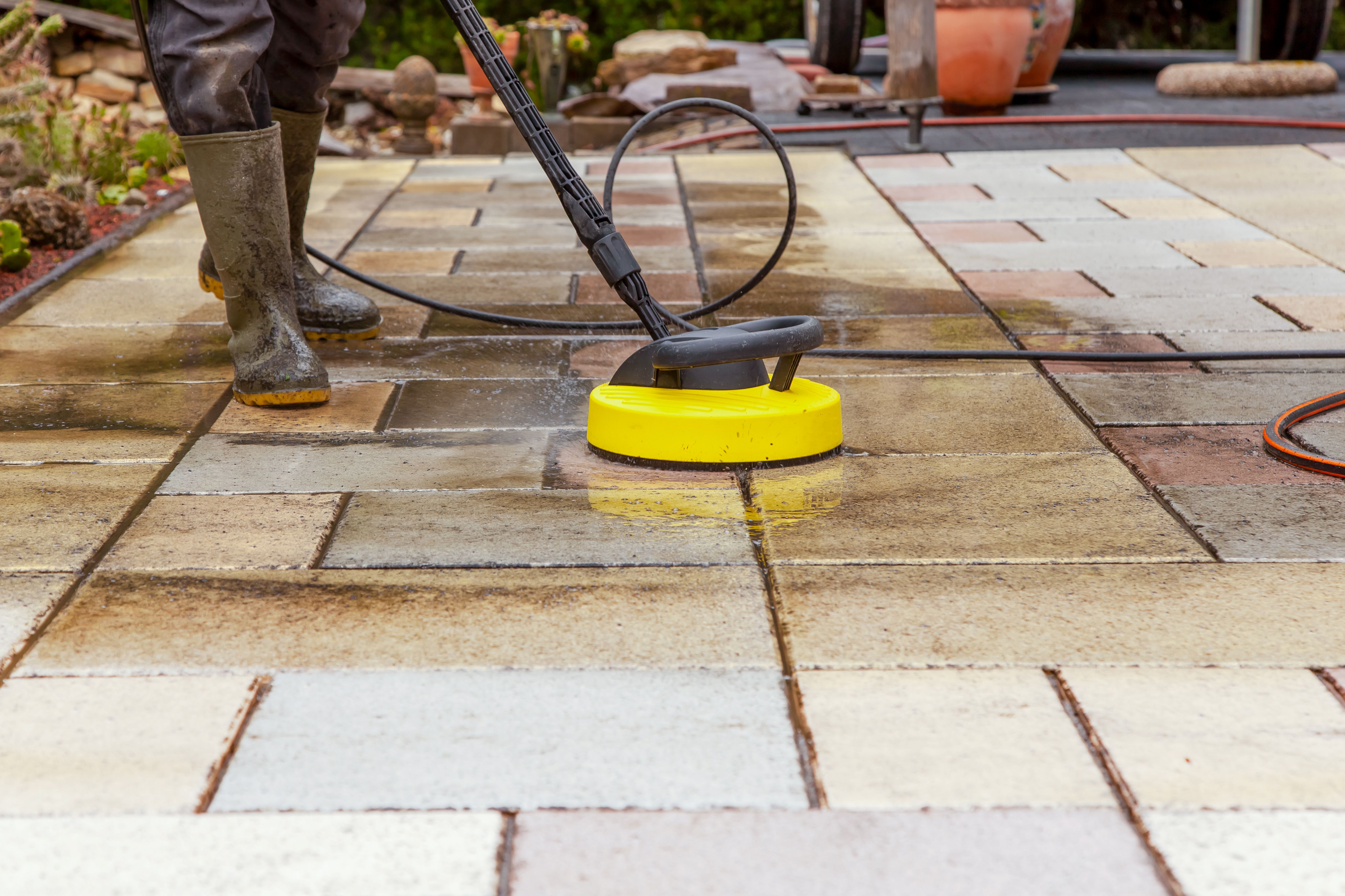 Cleaning stone slabs on patio with the high-pressure cleaner. Cleaning stone slabs on patio with the high-pressure cleaner.