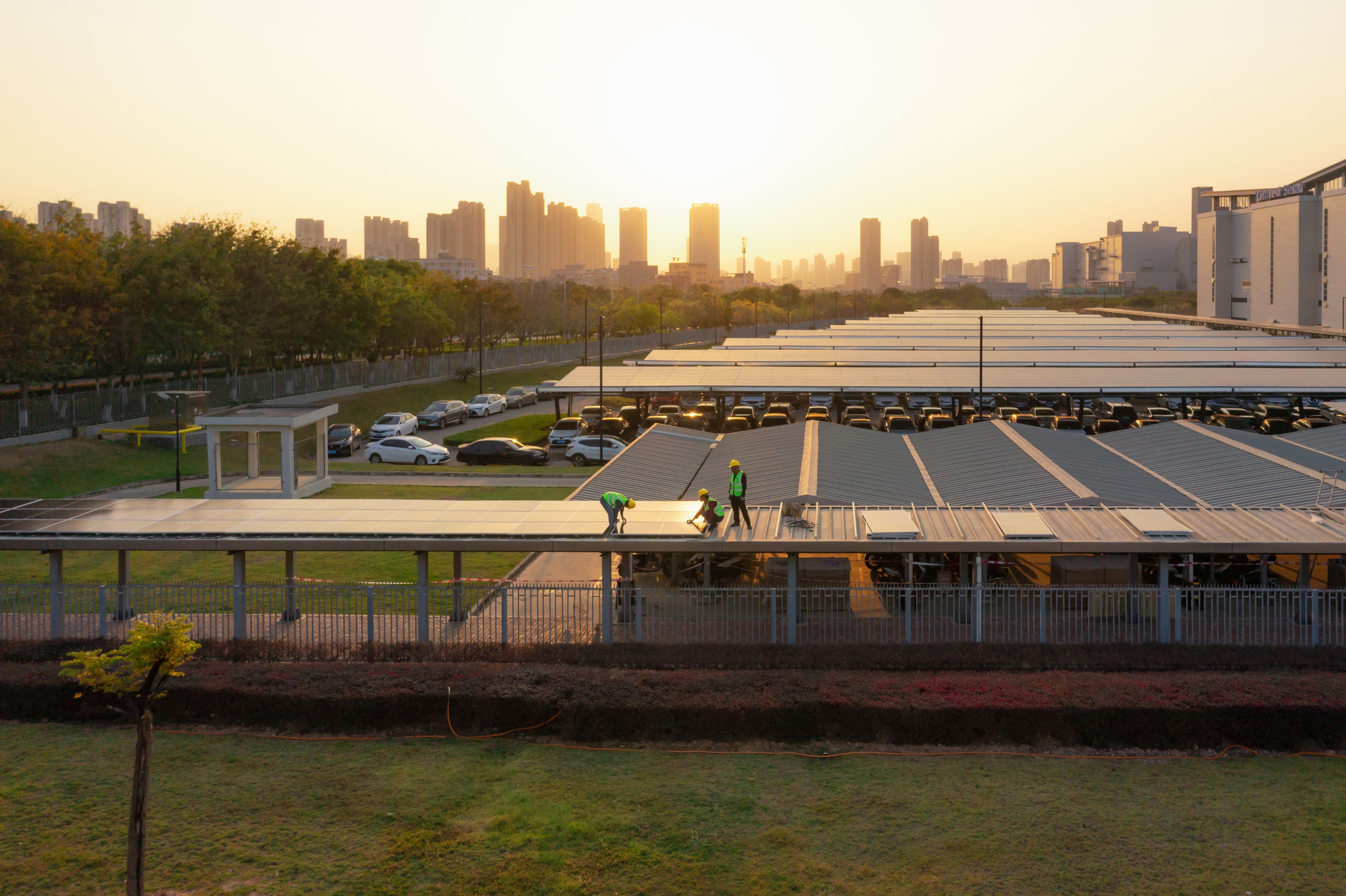 Workers are installing solar panels at sunset