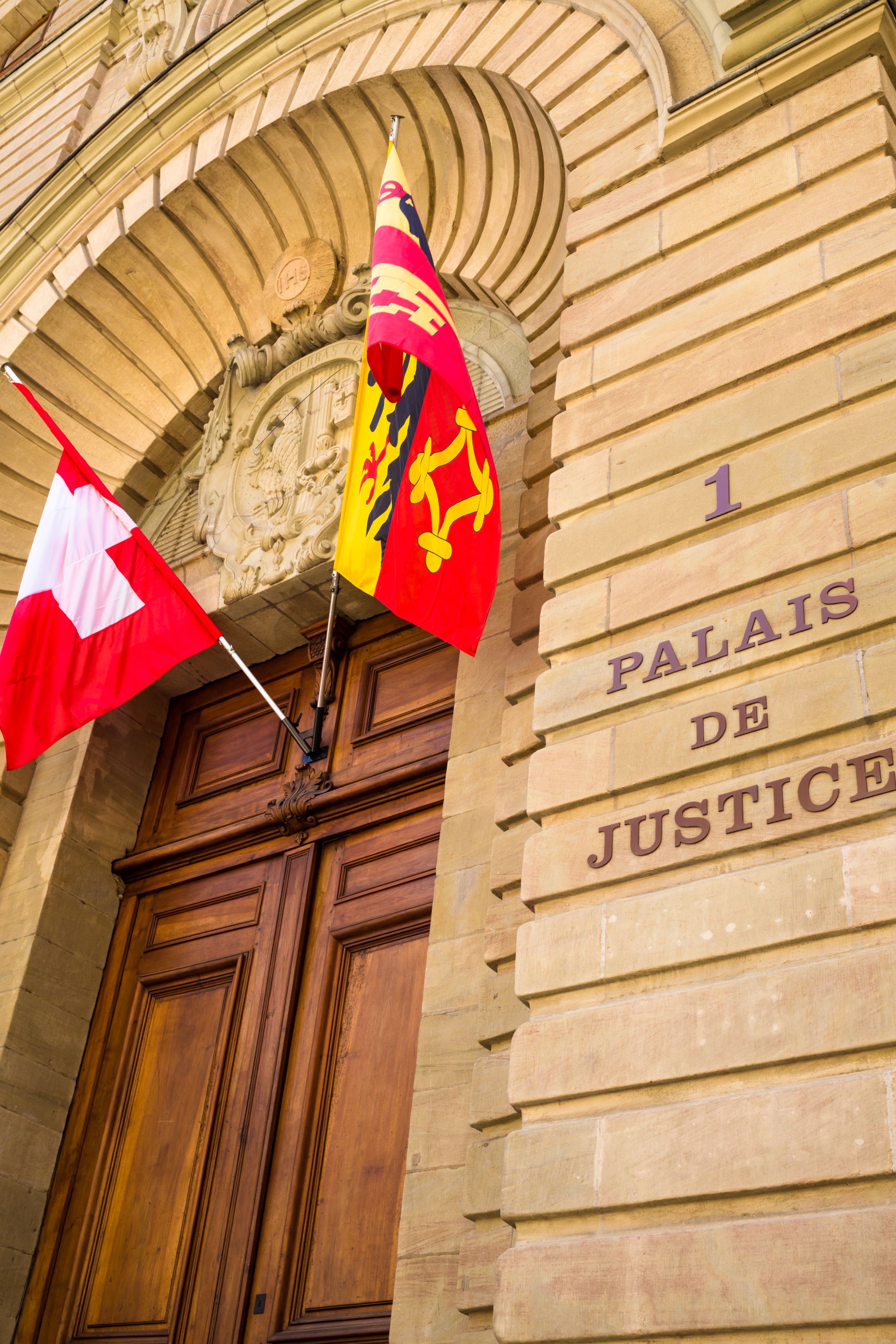 Tribunal de justice de Genève avec les drapeaux de la Suisse et du canton de Genève Tribunal de justice de Genève avec les drapeaux de la Suisse et du canton de Genève