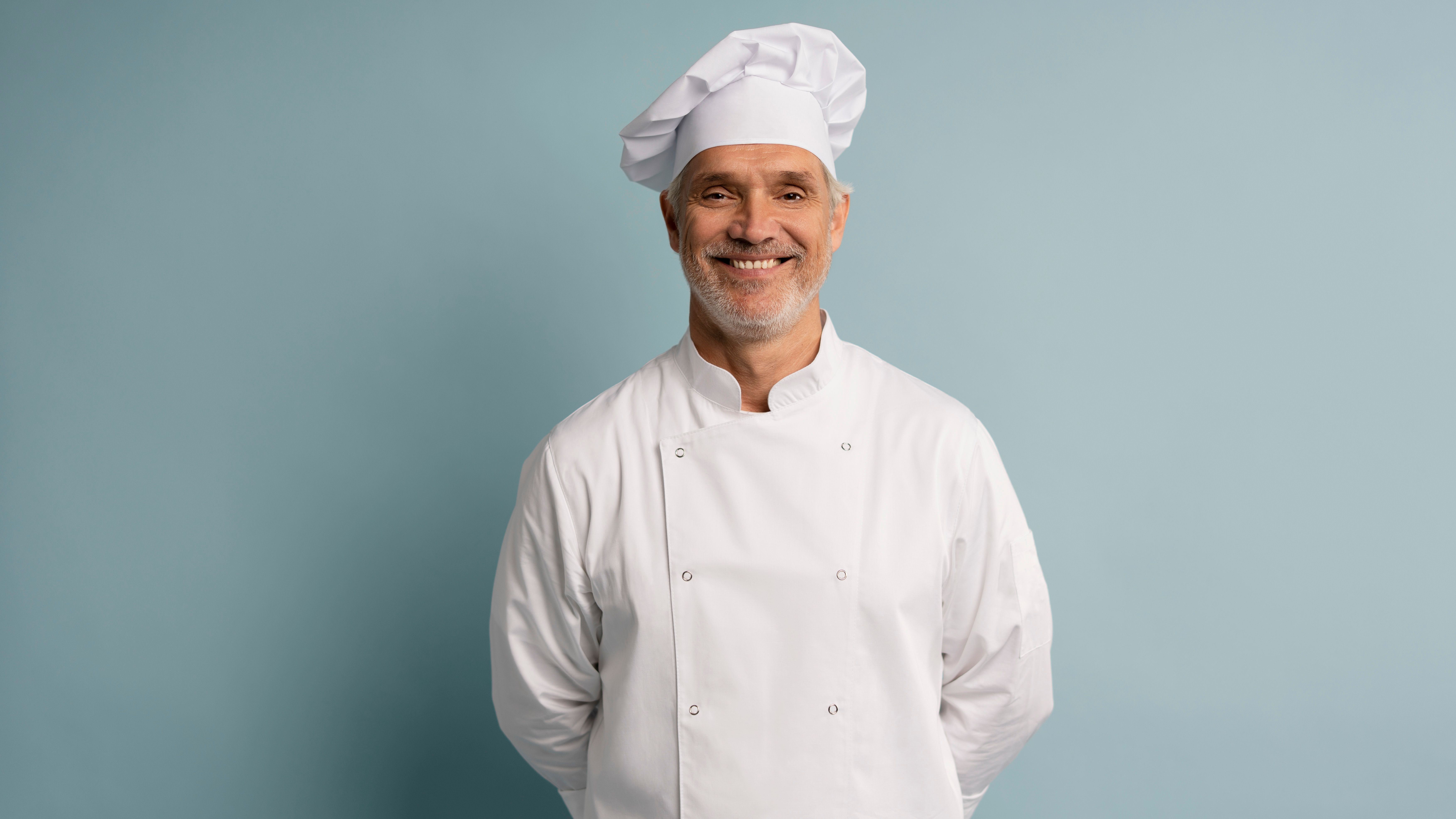 Happy chef in uniform on blue background.