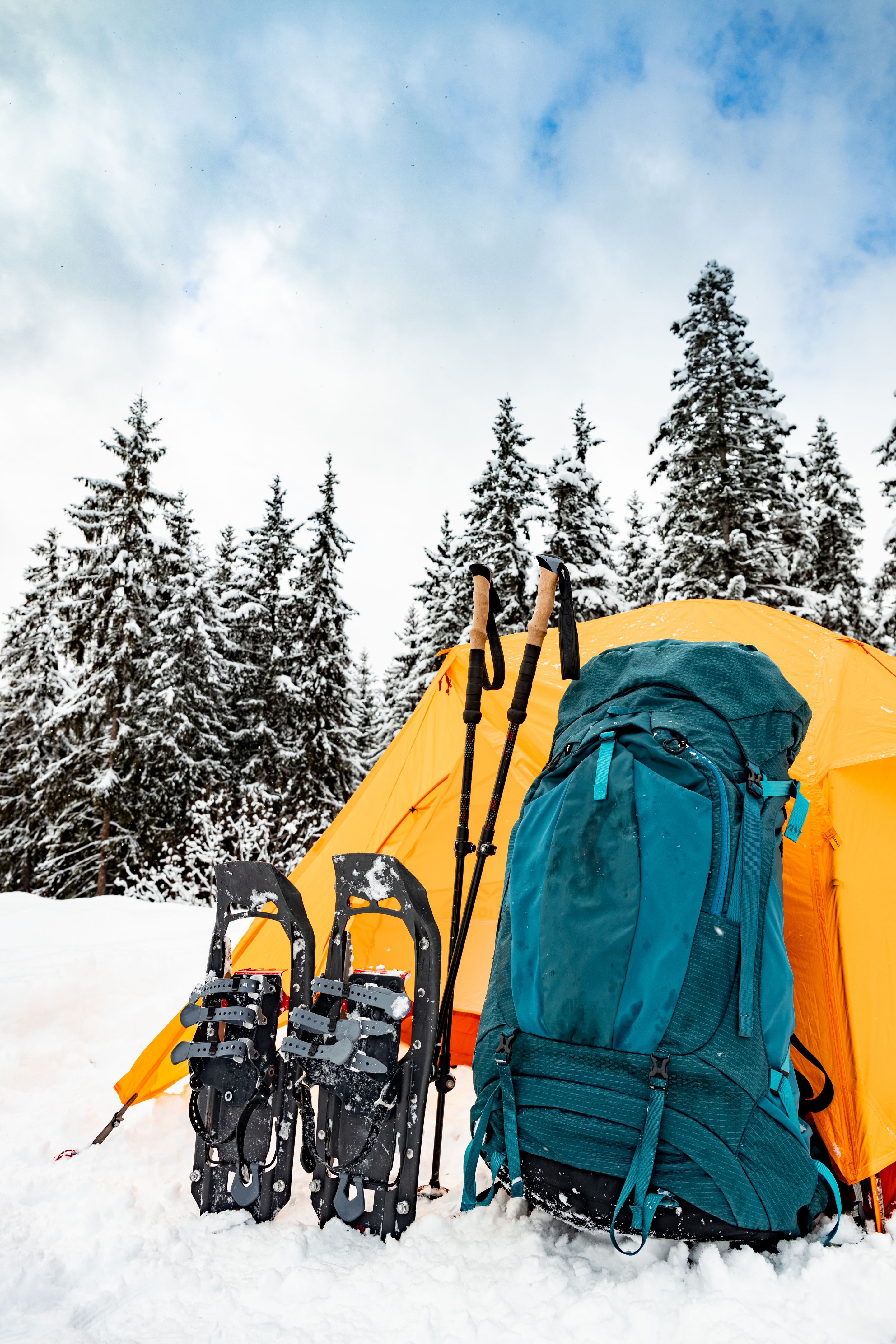 Camping in the winter forest with a backpack and a tent.