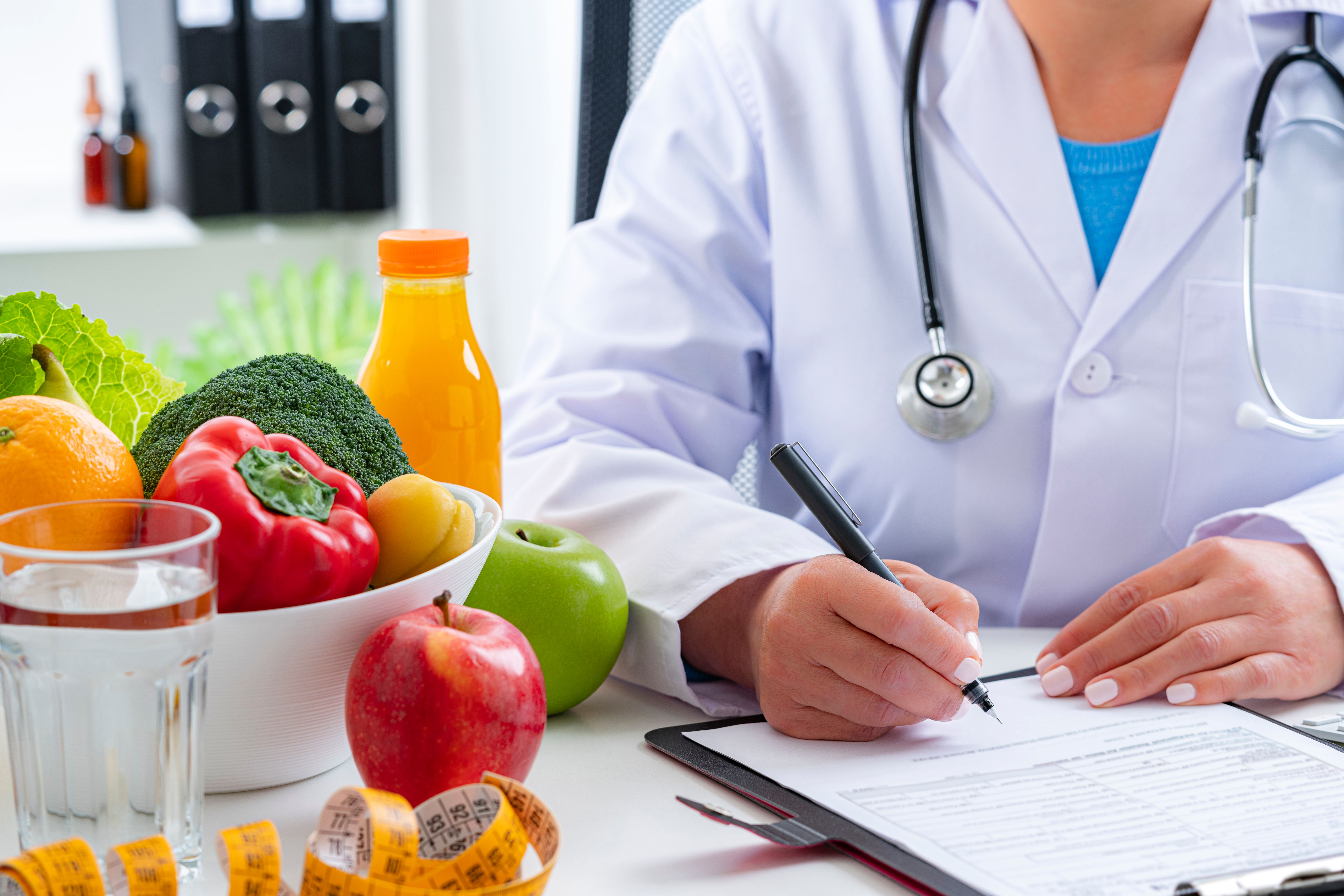 Nutritionist sitting at her desk writing a prescription