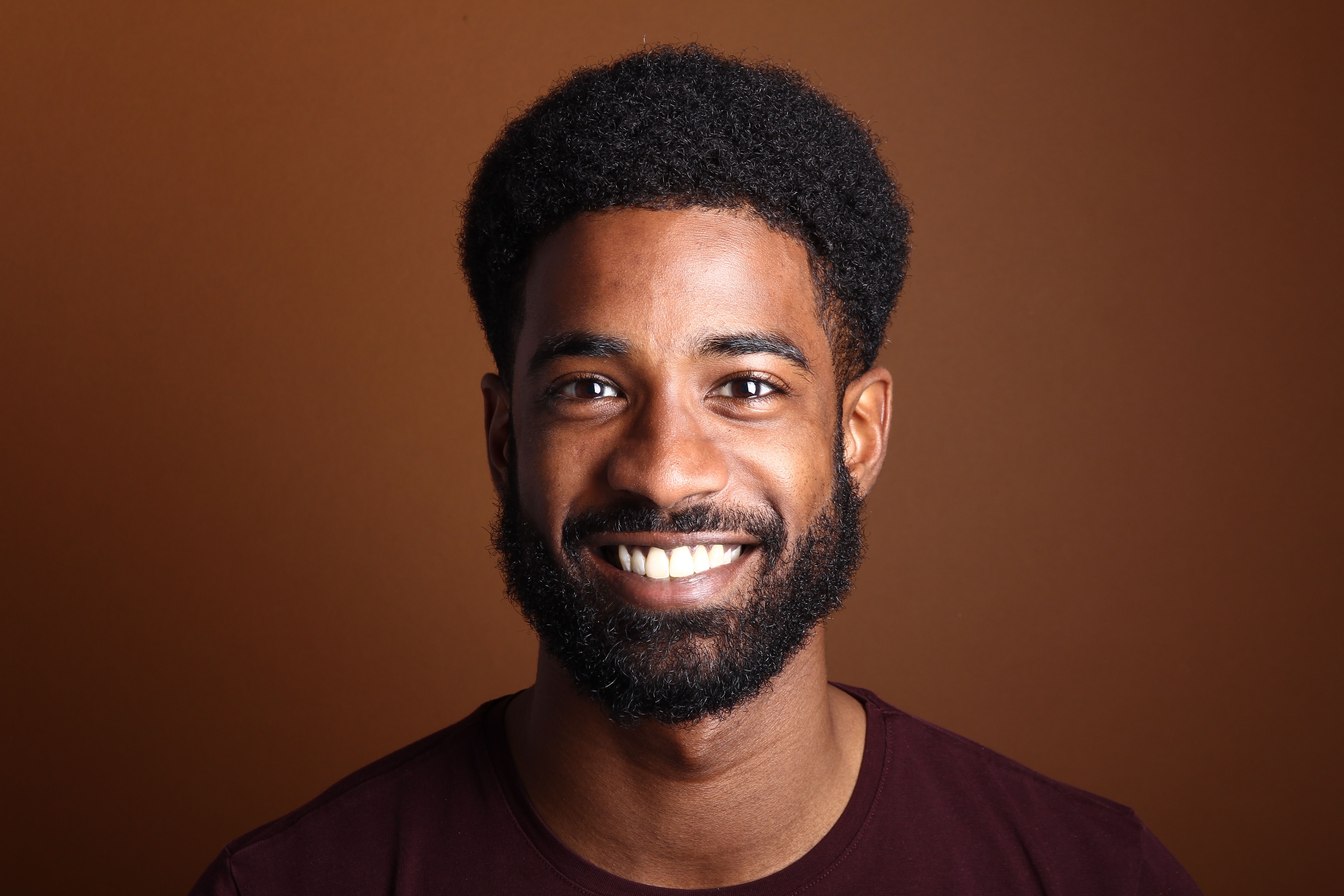 Beautiful black man in front of a brown background
