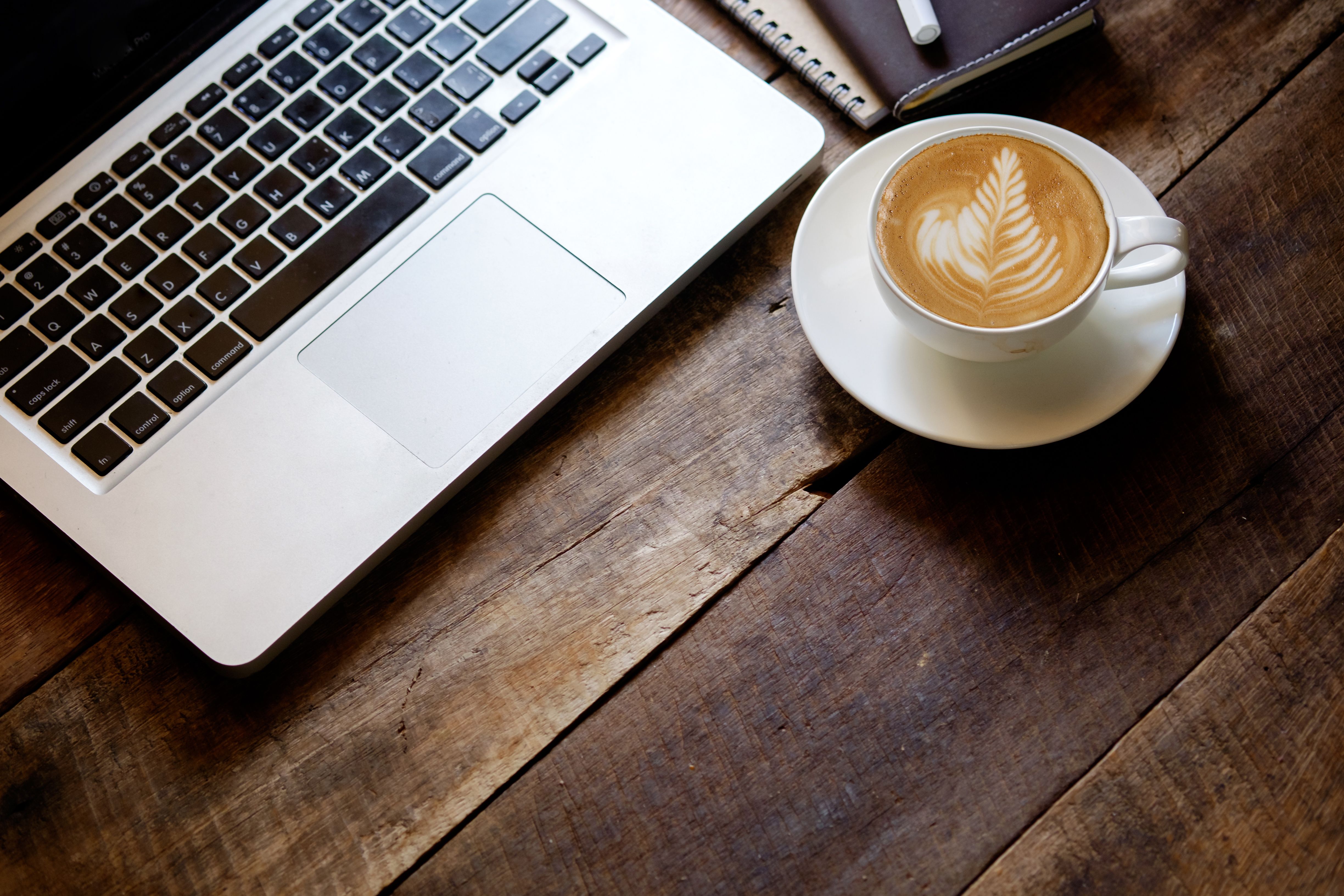 cup of latte art coffee and Laptop on wood table. cup of latte art coffee and Laptop on wood table.