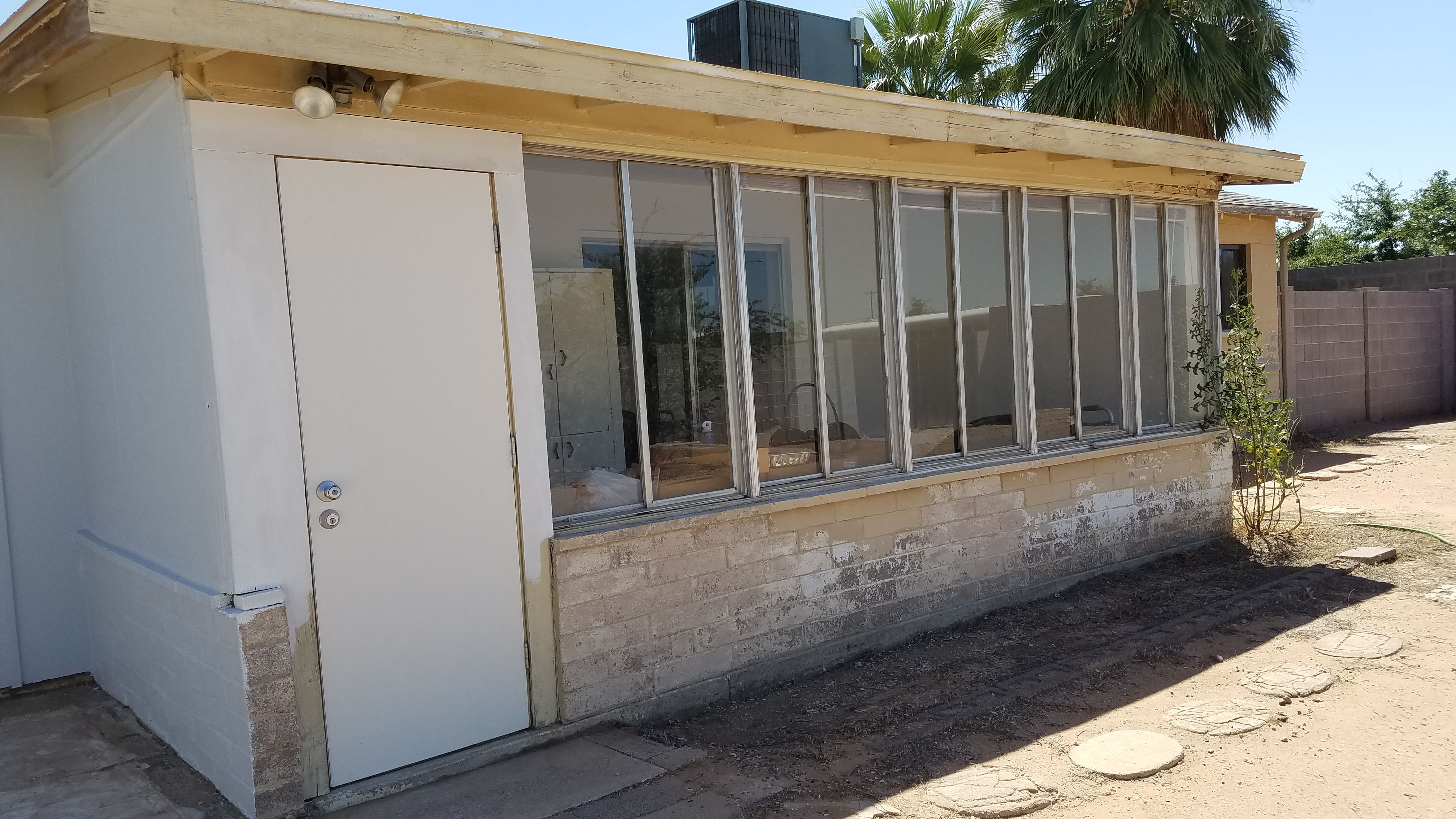 Enclosed Arizona Room with Peeling Paint on Old Brick House, Exterior