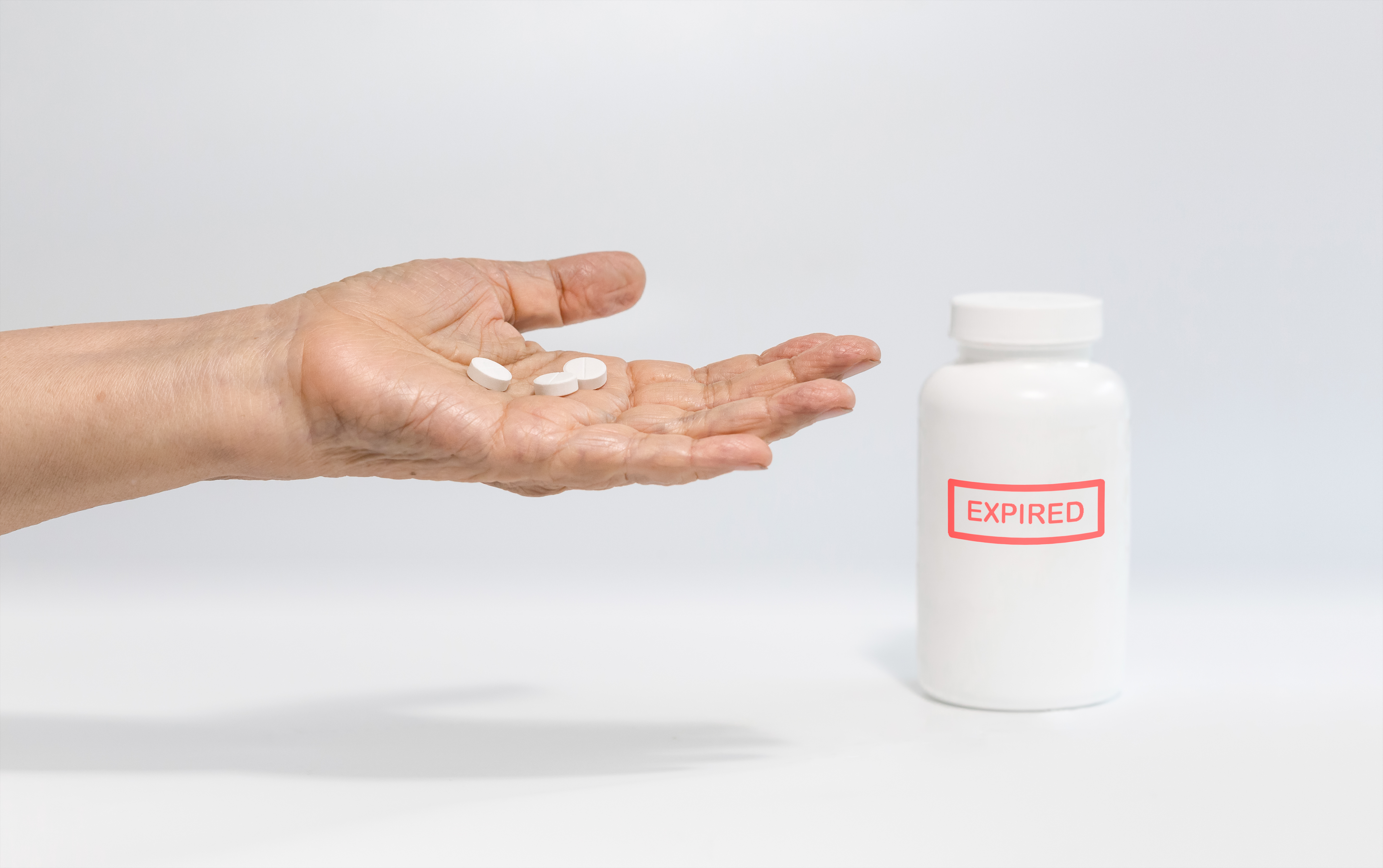 Expired drug on elderly hand Expired drug on elderly hand