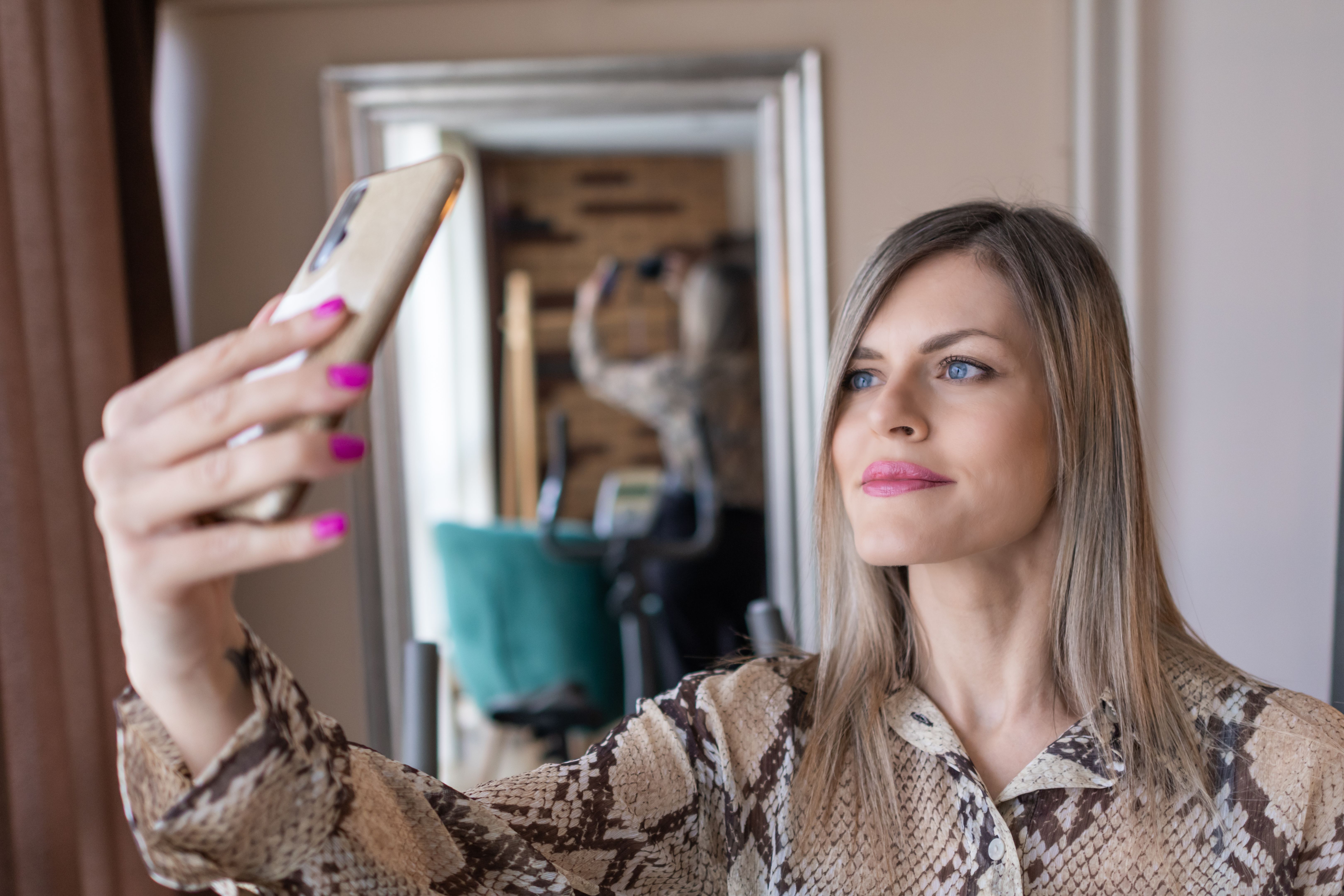 Elegant attractive businesswoman dressed up in formal clothes taking selfie with her mobile phone.