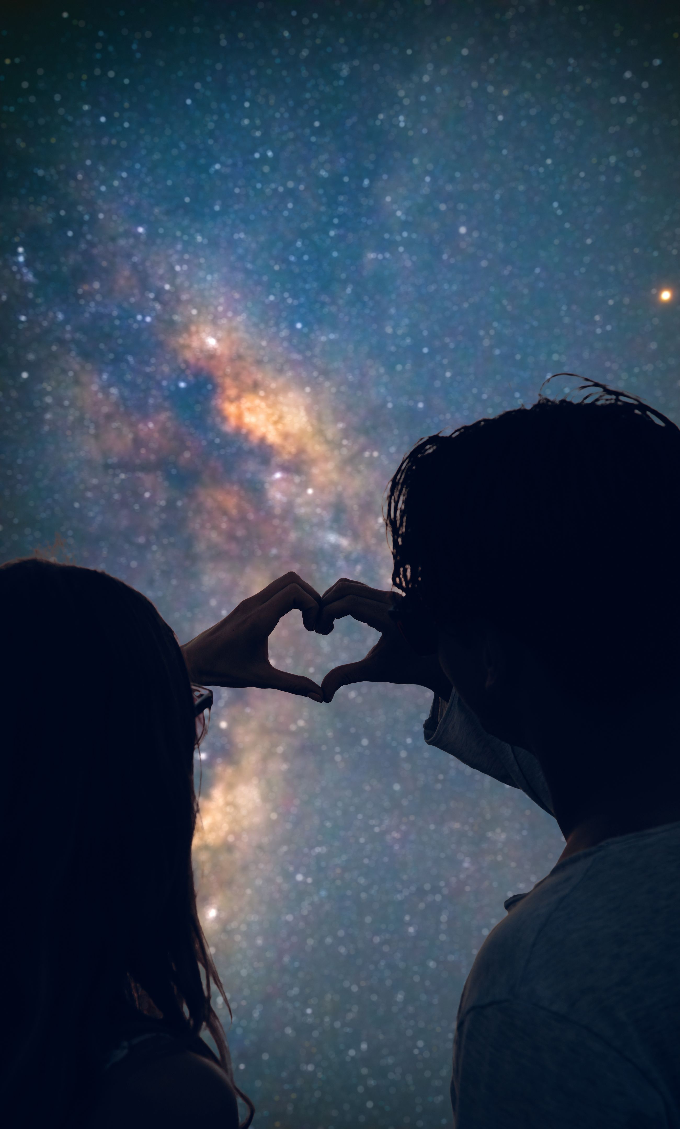 Couple making heart shape under the starry skies. Couple making heart shape under the starry skies.