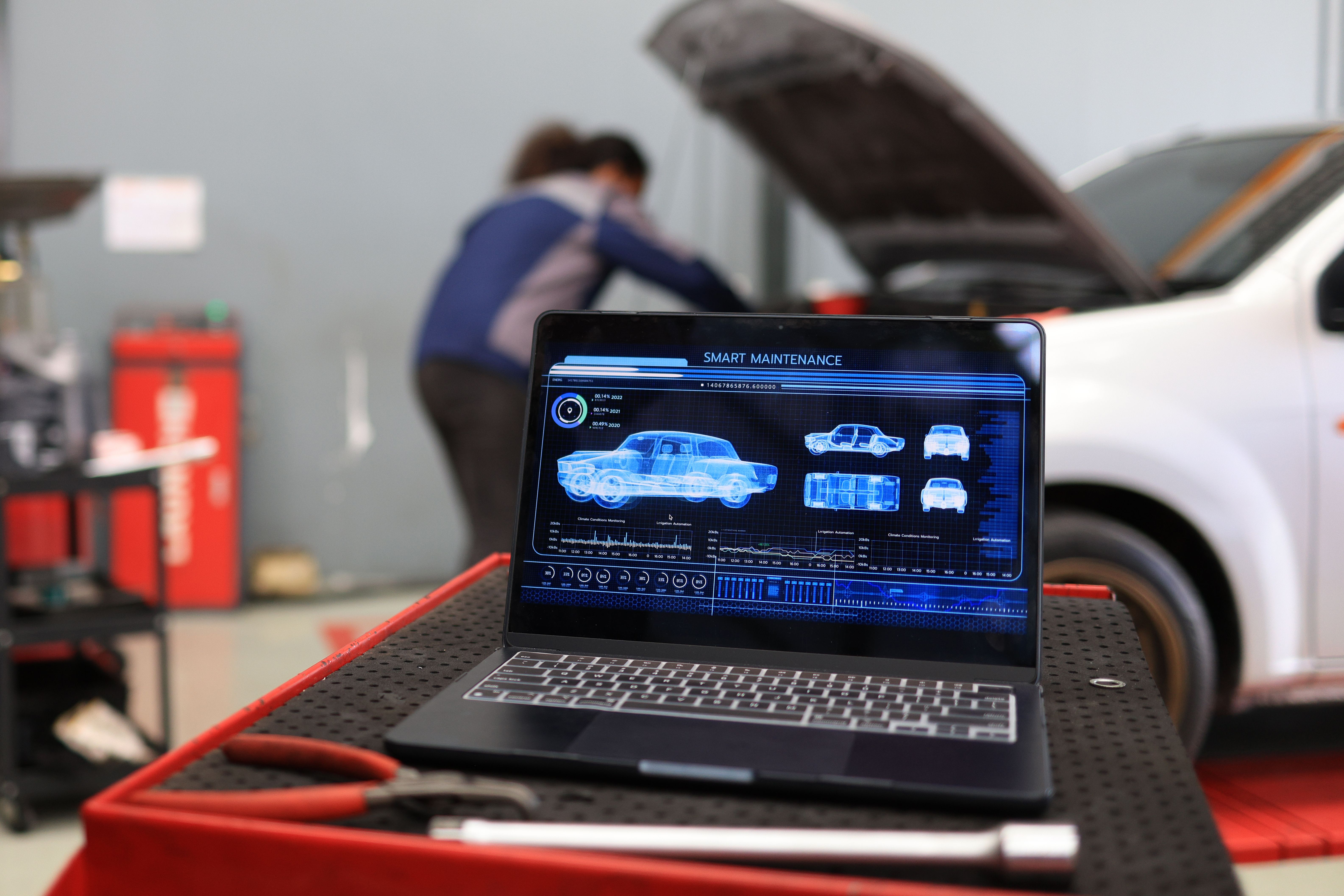 Foreman working on laptop with modern car service system control and manage care maintenance service system. Foreman working on laptop with modern car service system control and manage care maintenance service system.