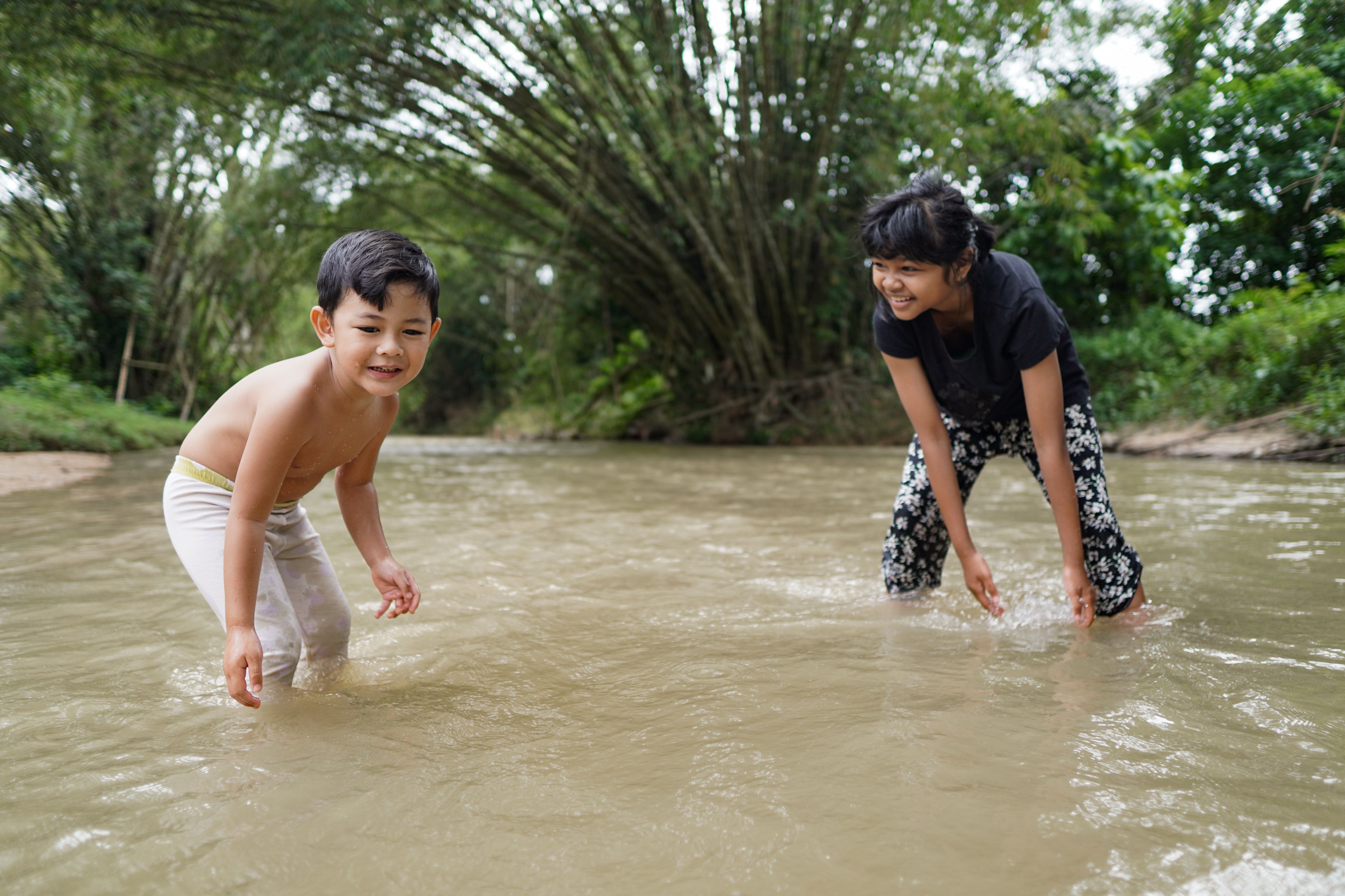 Cute Kids Siblings together Playing Sand pebbles at River Rural