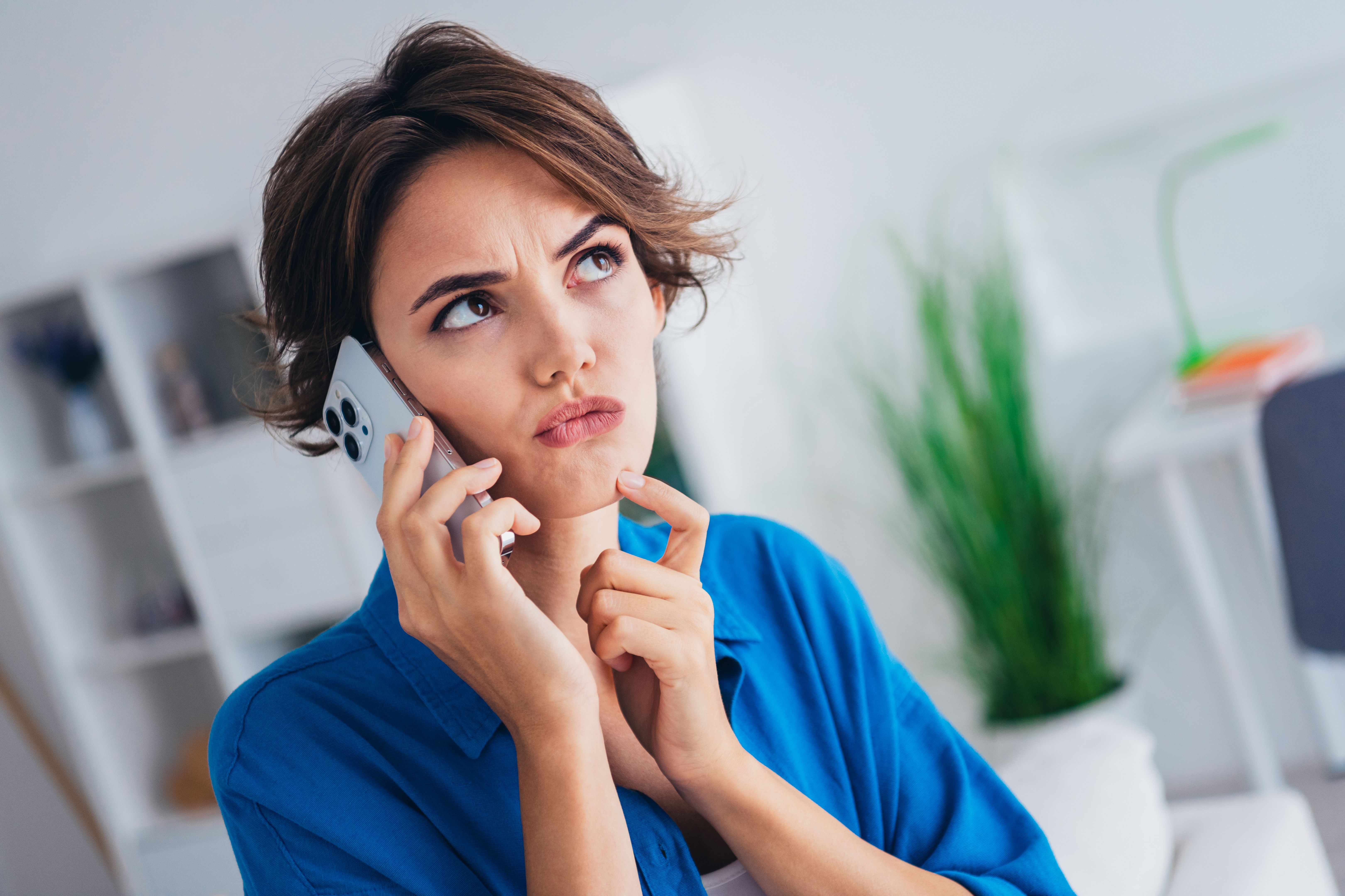 Photo of minded pensive girl finger touch chin speak chatting telephone hesitate ponder bright interior indoors