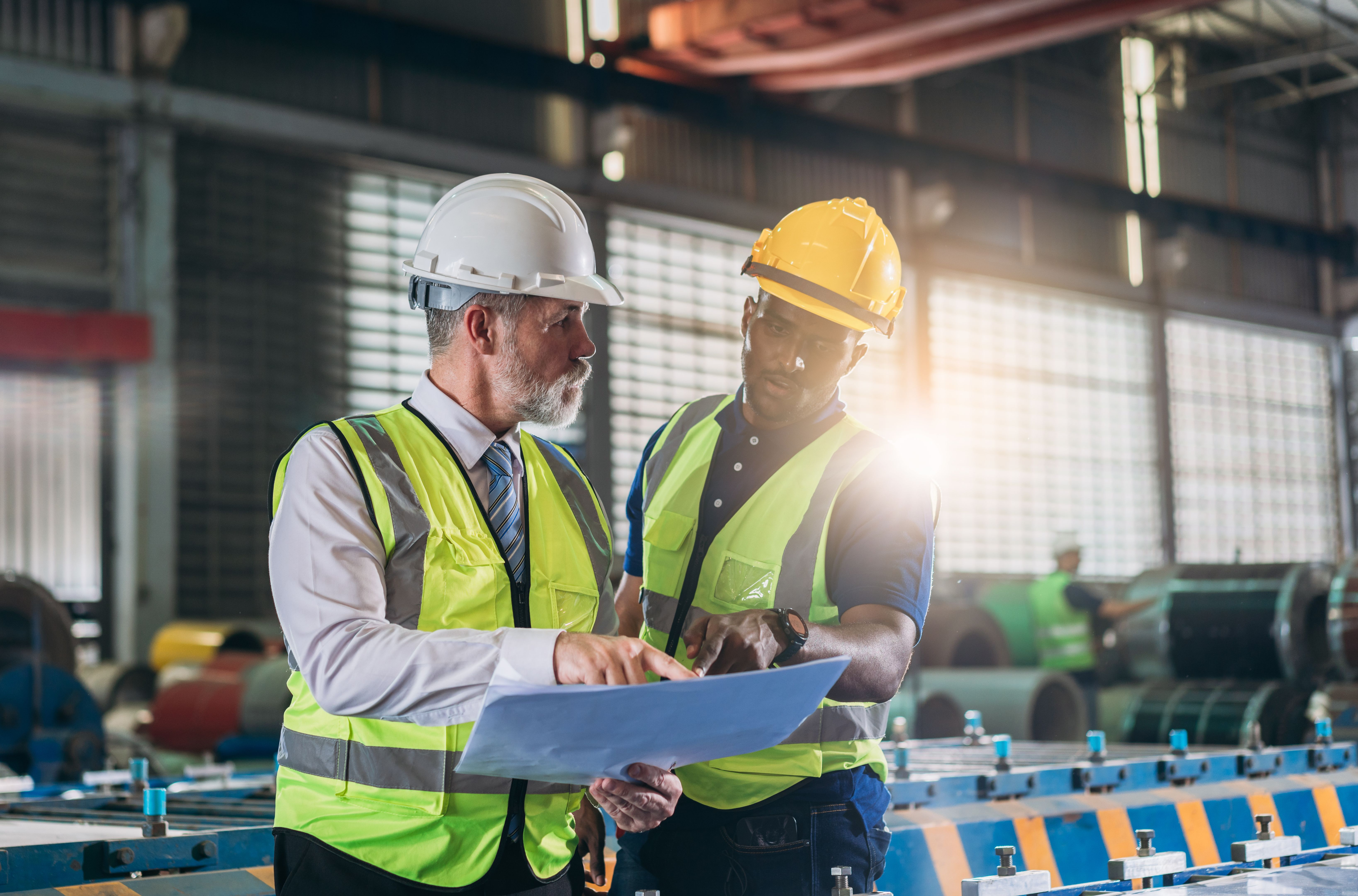 Industrial worker inspecting and check up machine at factory machines.Technician working in metal sheet at industry.