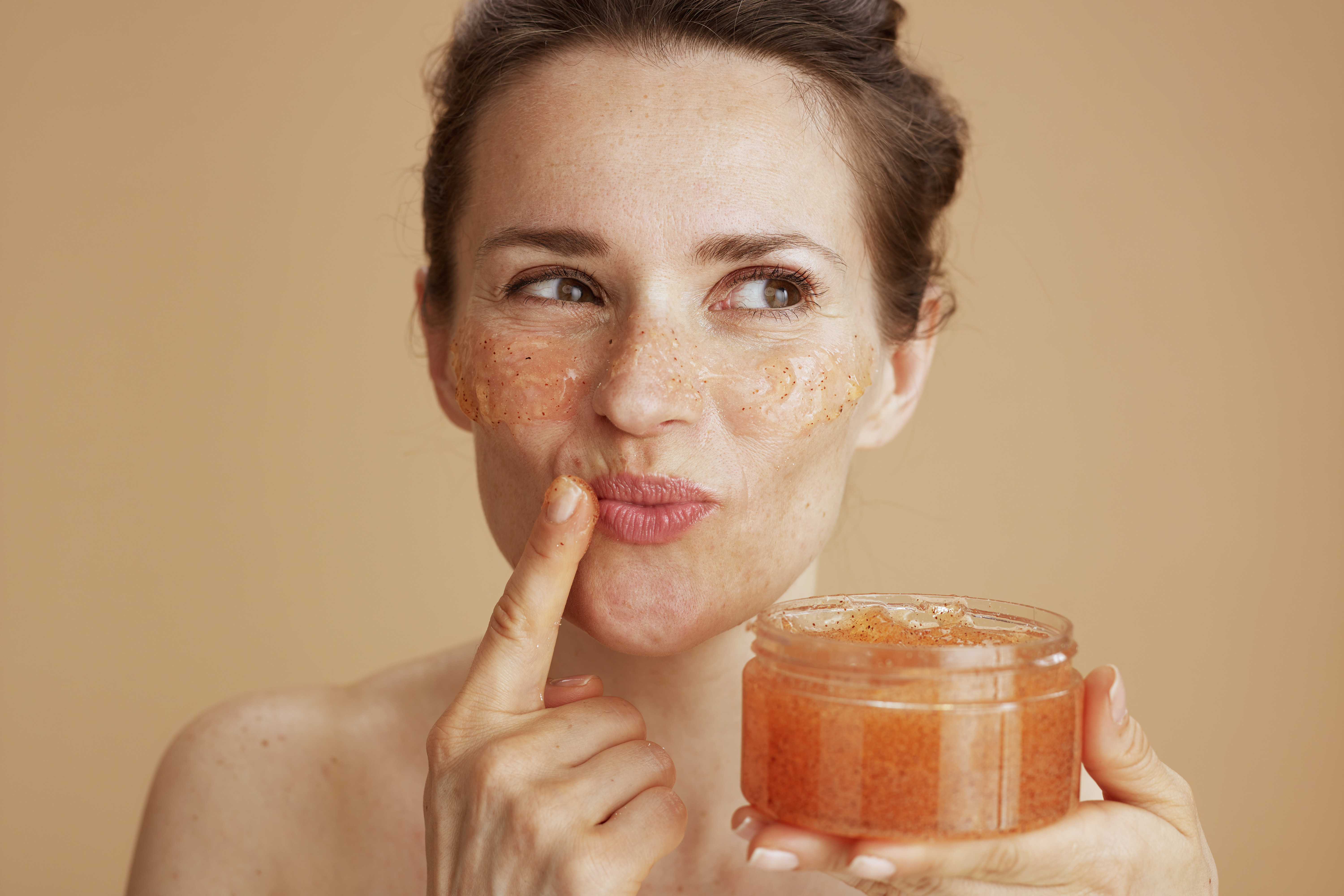 happy modern woman with face scrub