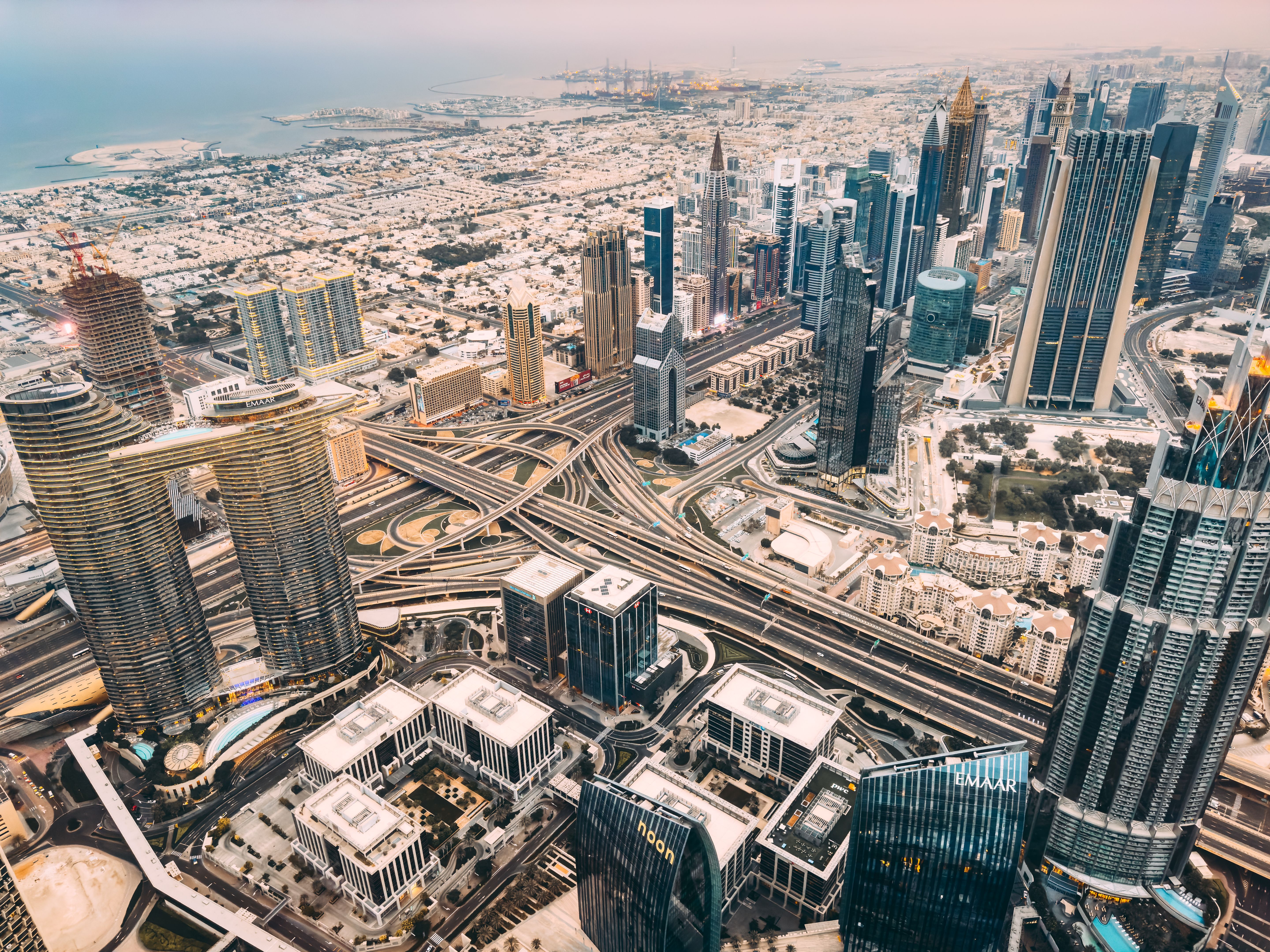 Aerial view of Downtown Dubai with roads, Dubai Mall and the fountain at sunrise, from Burj Khalifa observatory deck in United Arab Emirates