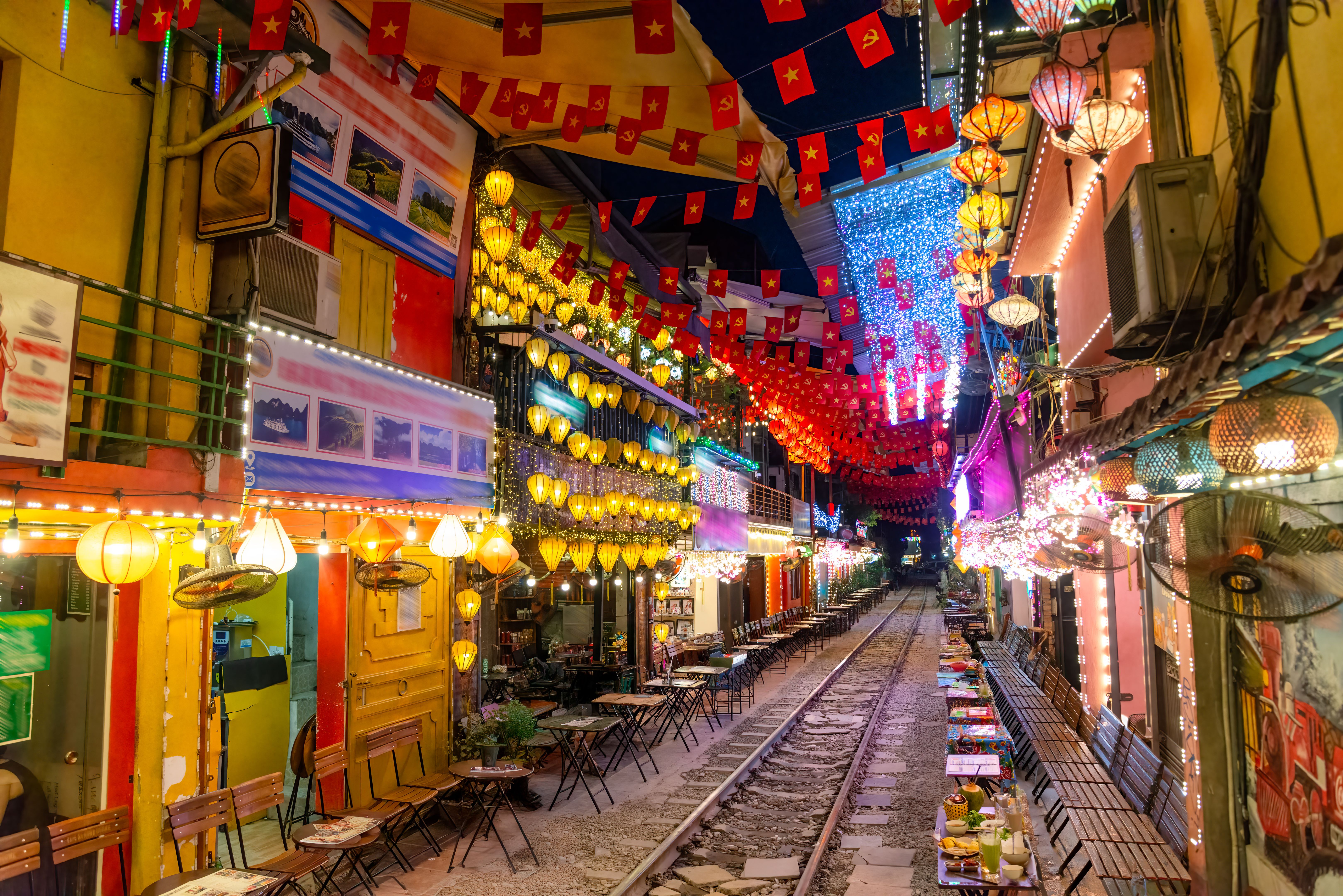 Old Quarter Hanoi street at dusk with motorbikes and warm lantern light