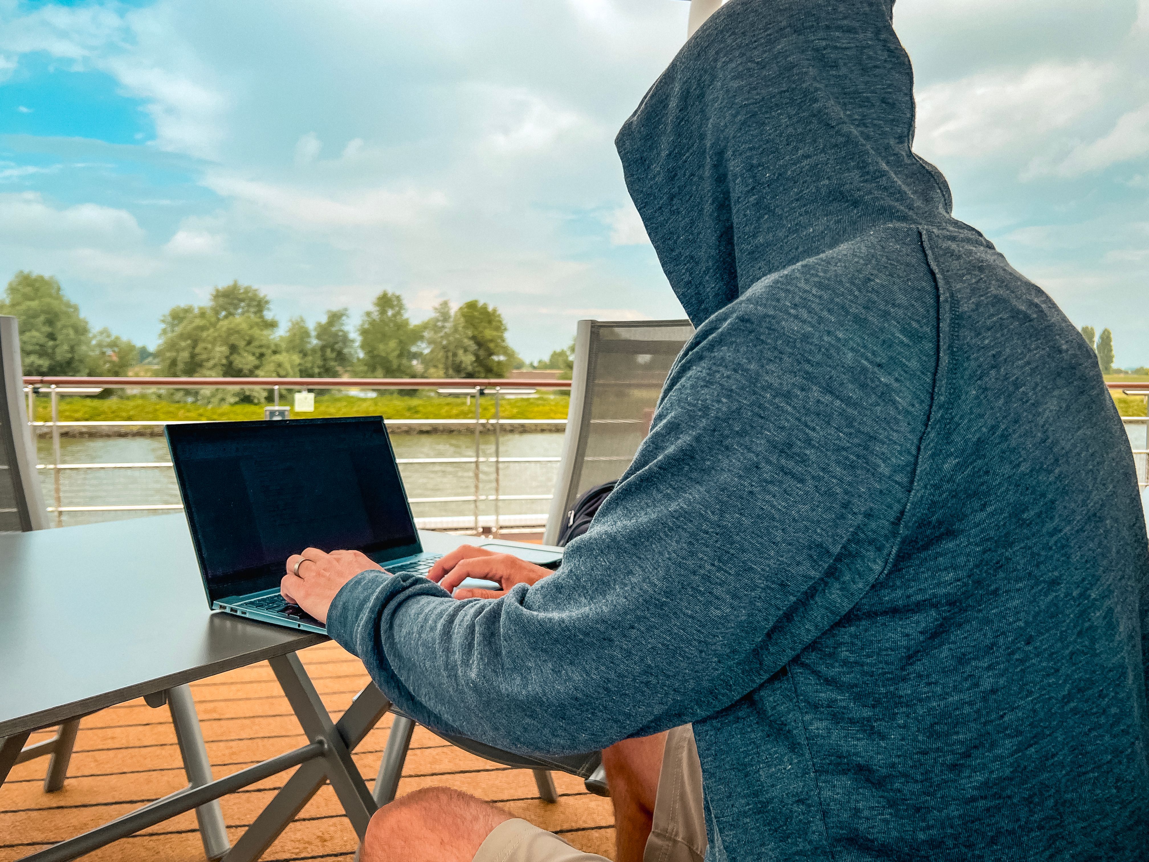 Man Works on His Laptop Computer on a Moving Boat