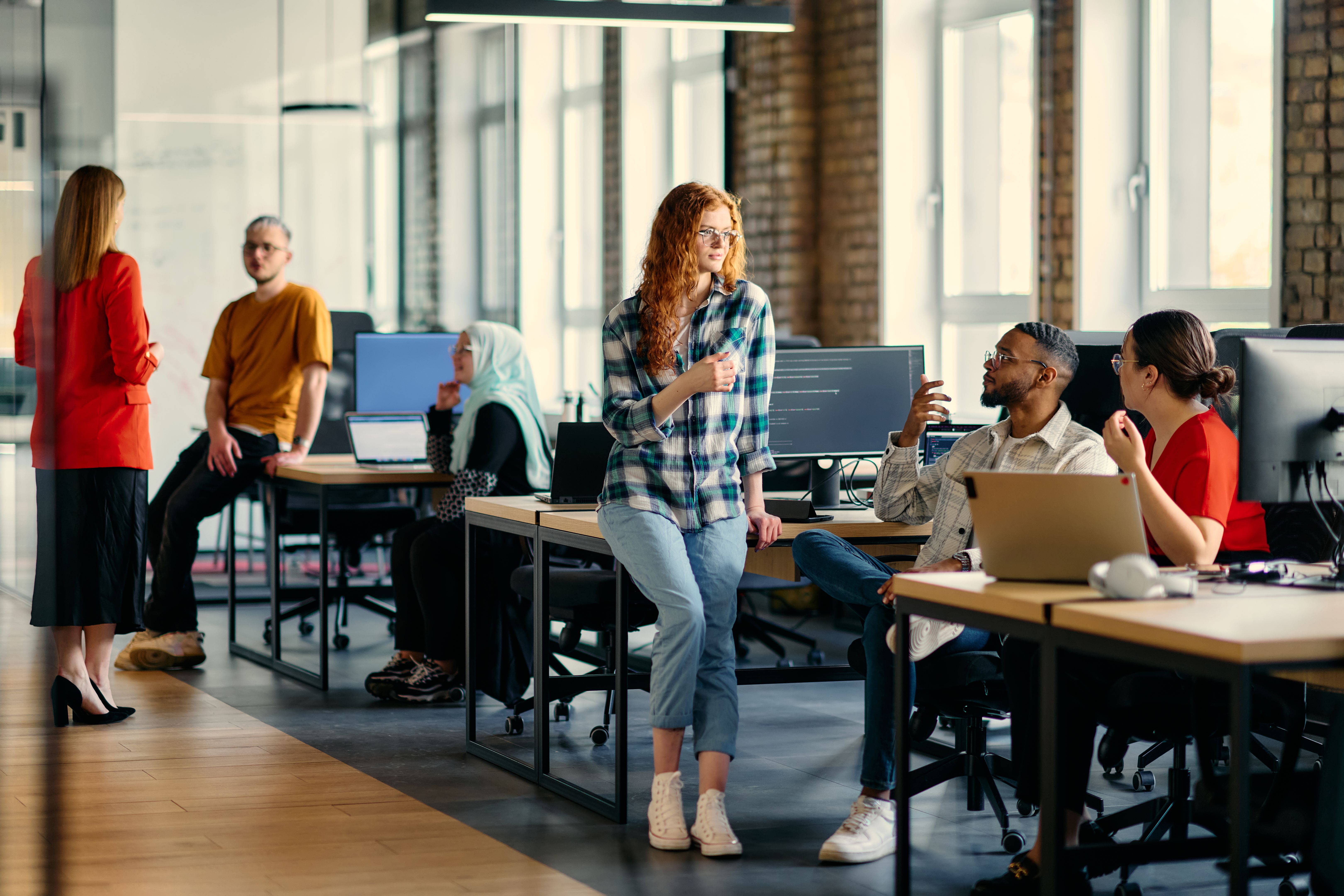 A diverse group of young business individuals congregates in a modern startup coworking center, embodying collaborative innovation and a dynamic atmosphere