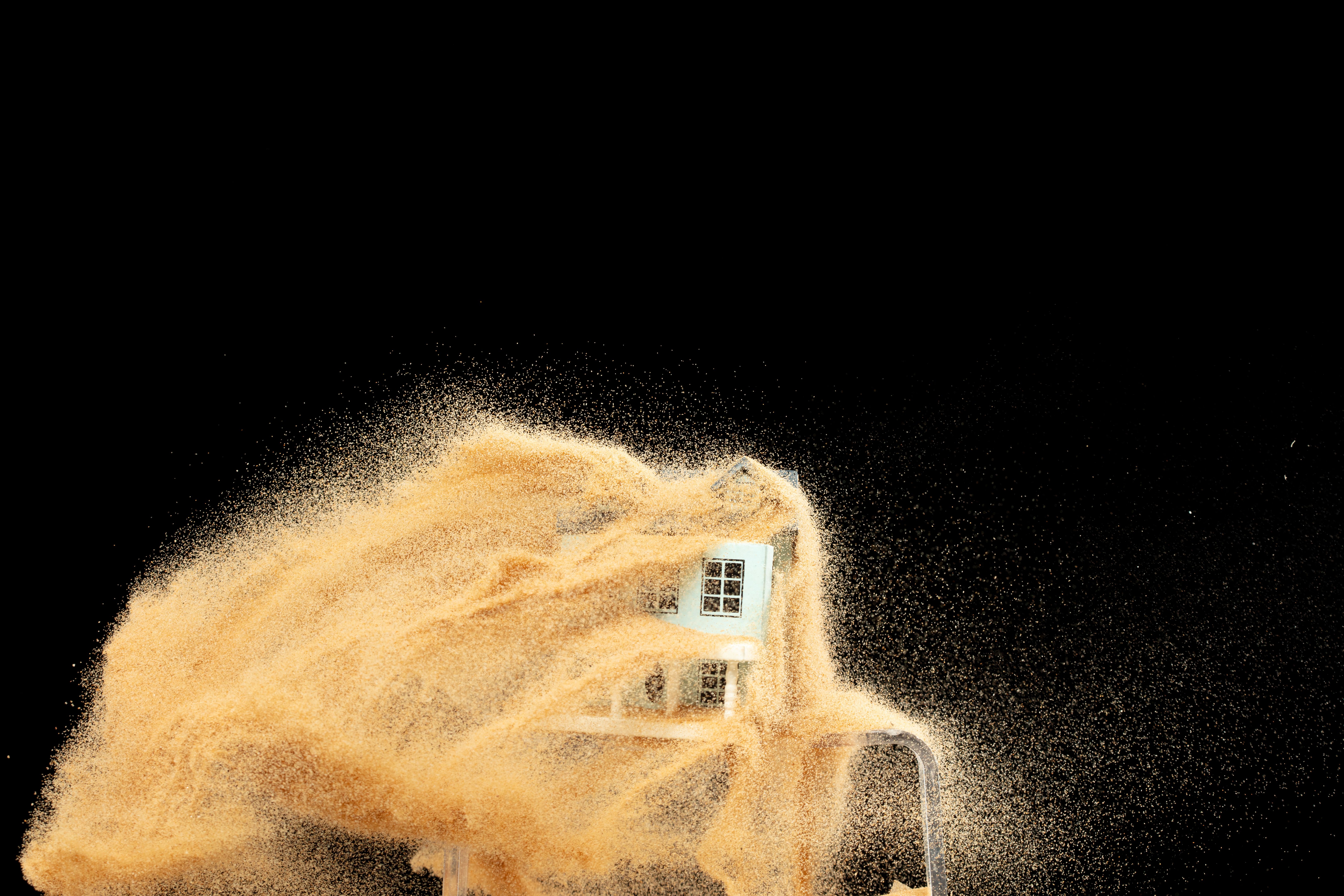 Sand storm hit House as natural disaster from climate change global warming. Strong wind of sand attack house with insurance create loss damage environment. Black background isolated
