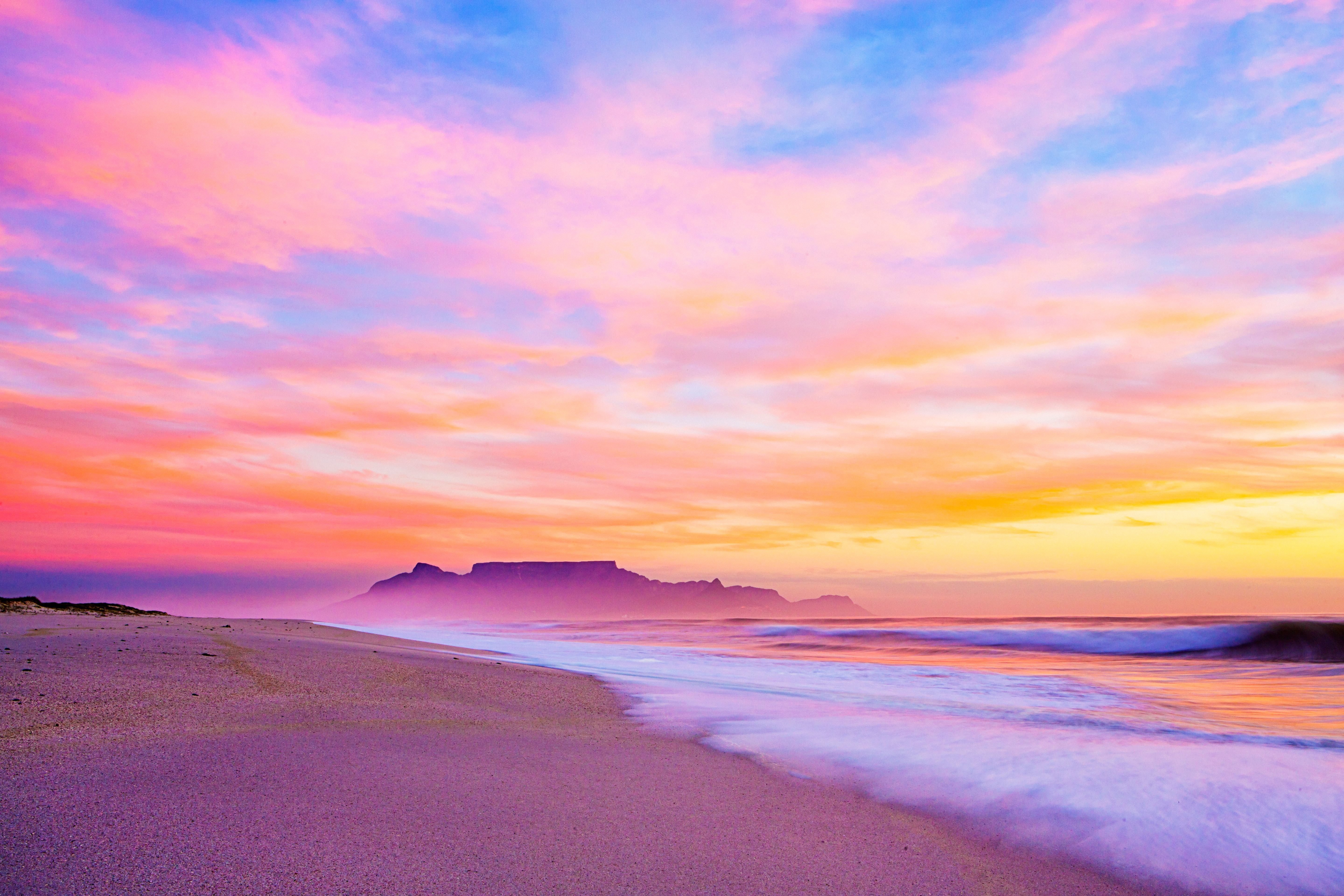 Sky over Cape Town's Table Mountain lights up in beautiful pinks, blues, yellows and oranges