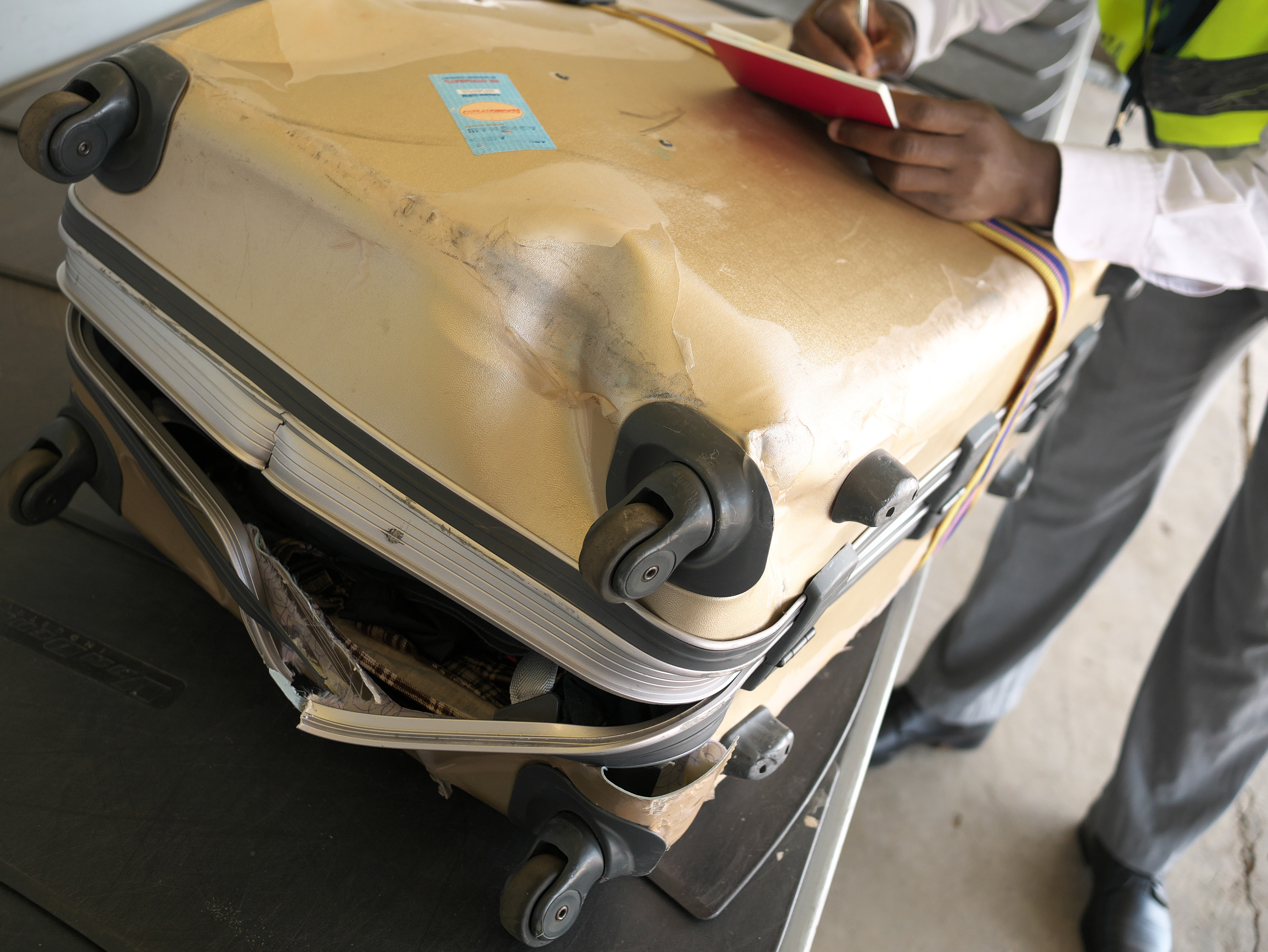 A completely broken suitcase due to poor handling at an airport
