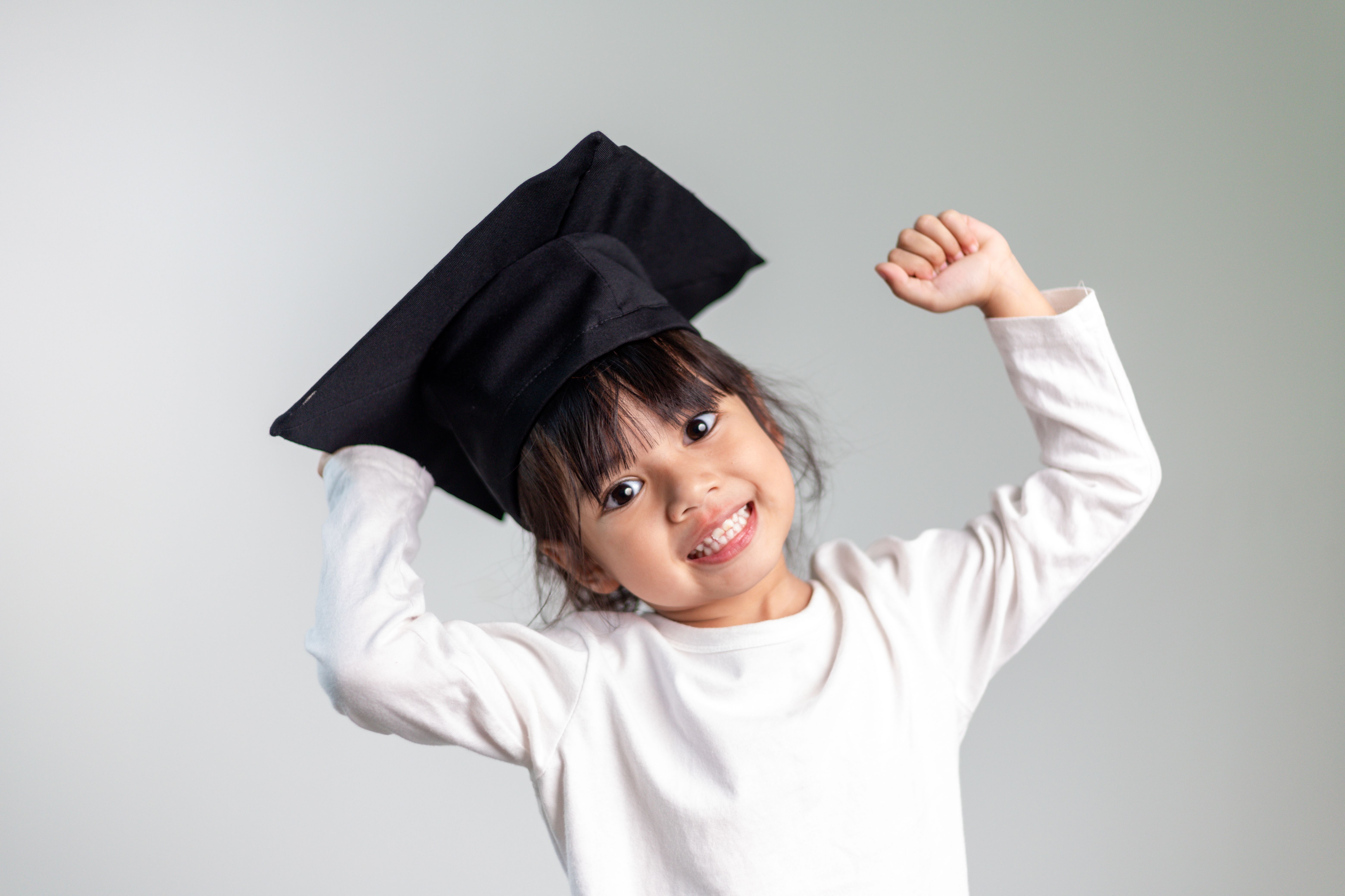 Happy Asian school kid graduate in graduation cap Happy Asian school kid graduate in graduation cap