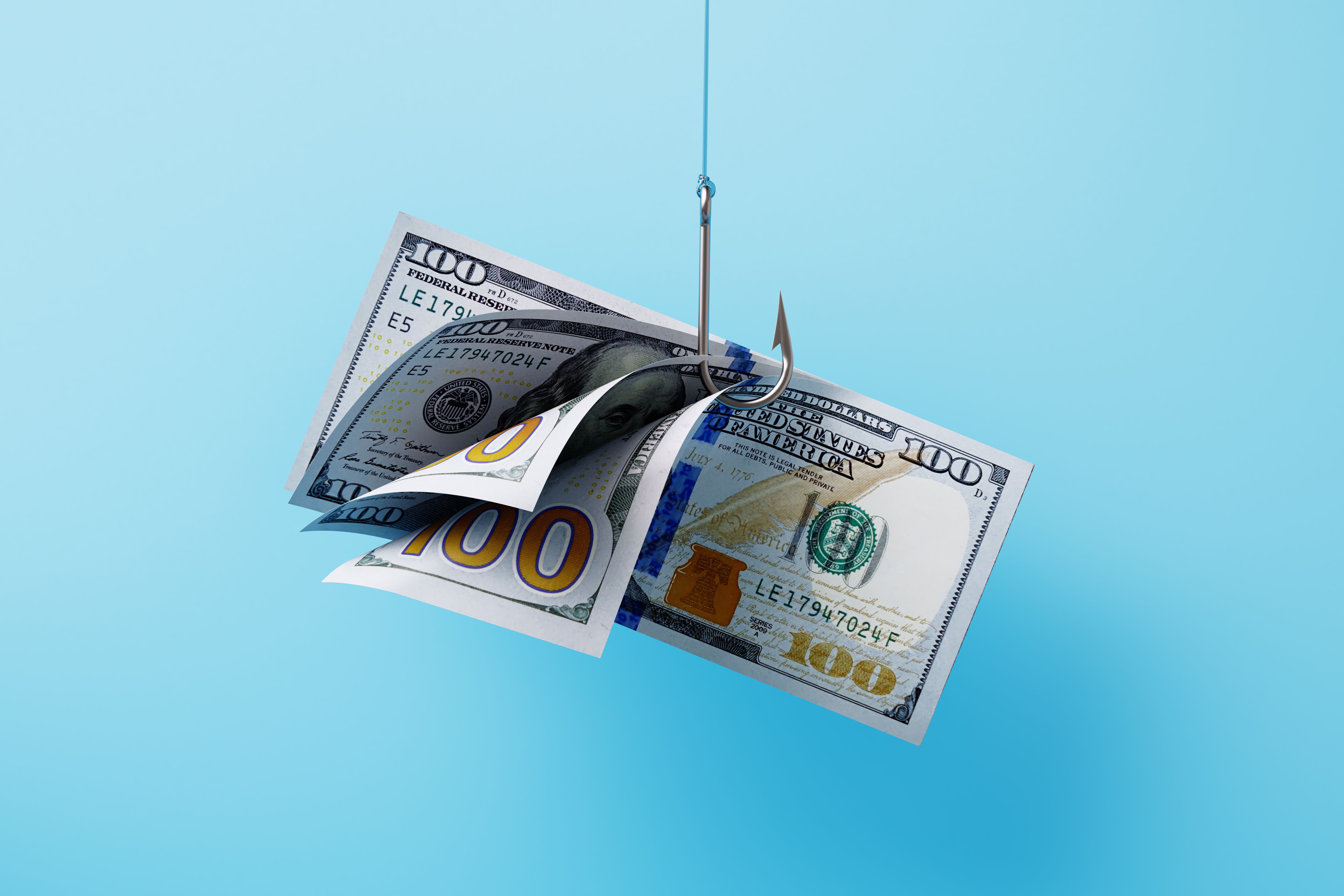 A Group Of australian One Hundred Dollar Bills Hooked By A Fishing Hook On Blue Background - Phishing And Fraud Concept A Group Of australian One Hundred Dollar Bills Hooked By A Fishing Hook On Blue Background - Phishing And Fraud Concept