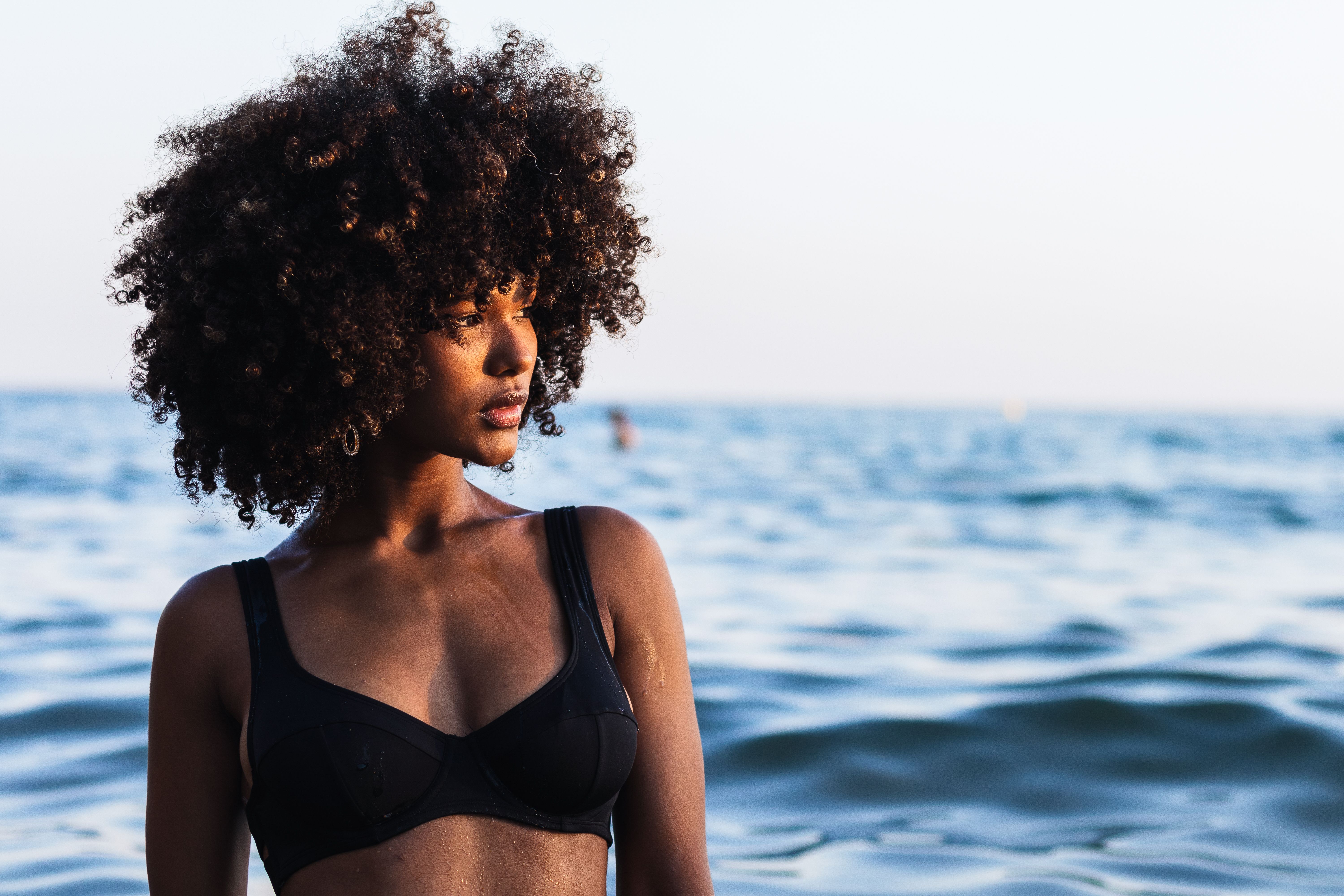 Calm ethnic woman in bikini in sea
