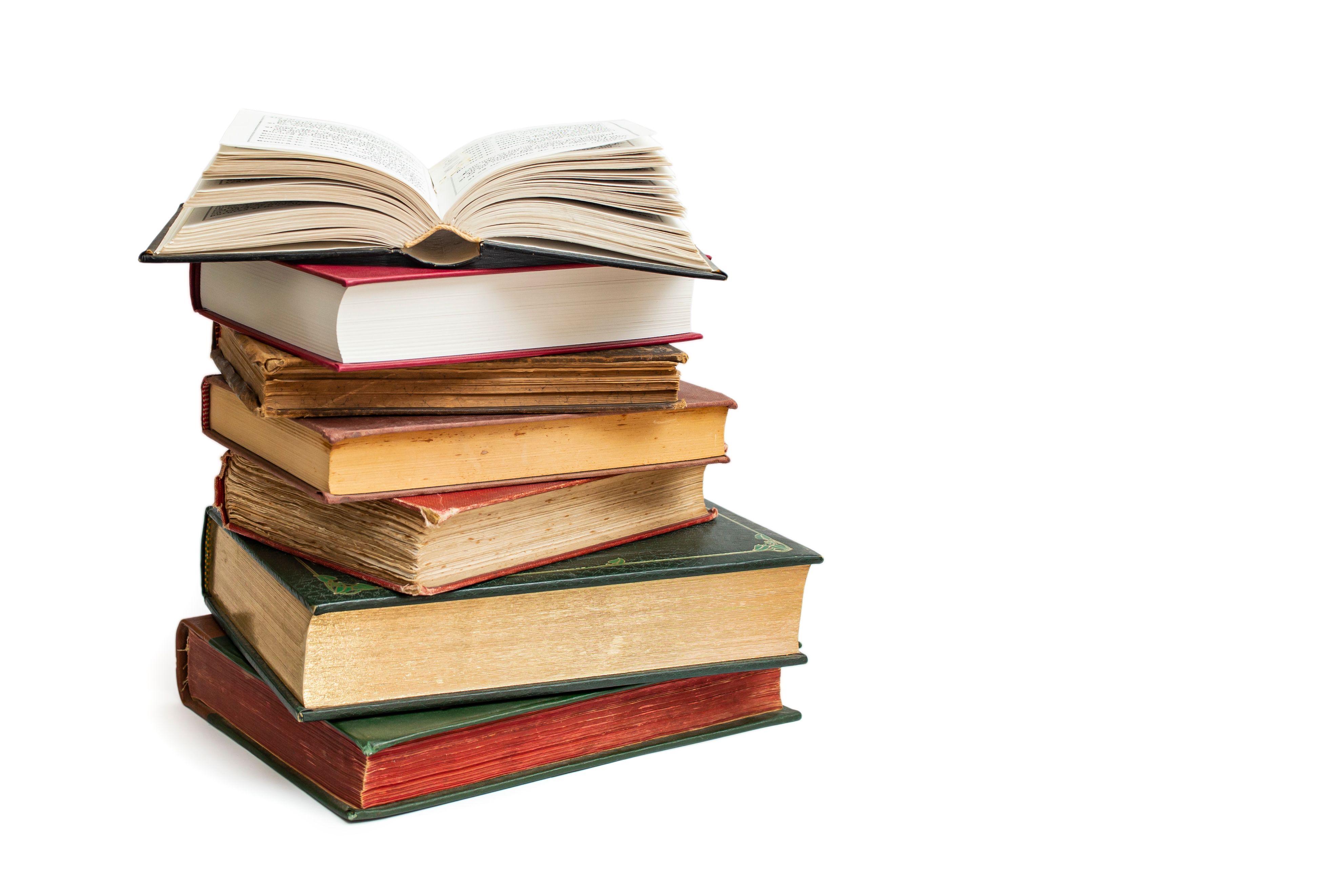 Vintage hard cover books stacked with an opened book on top, isolated on white background, abstract backdrop