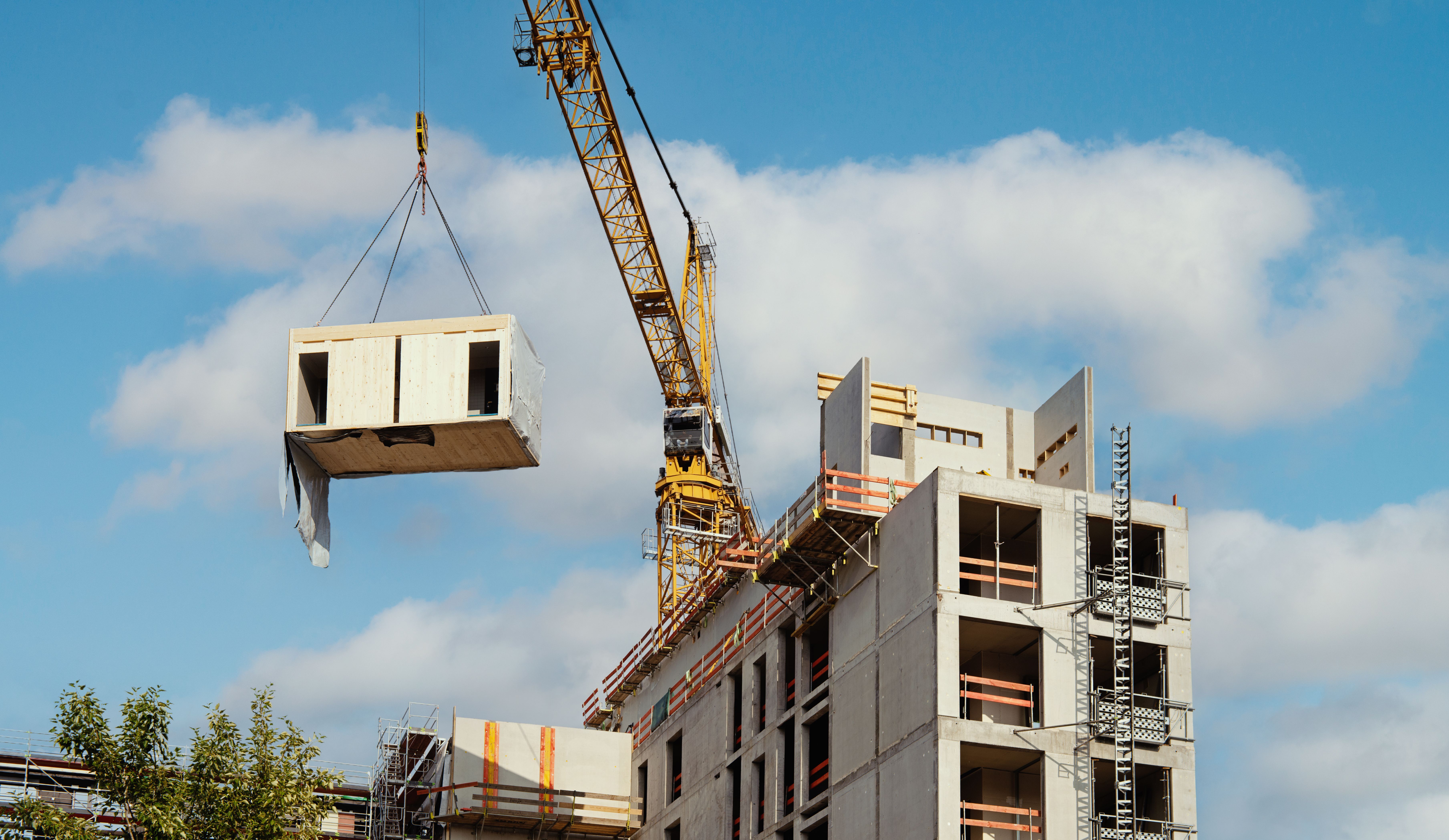 Crane lifting a wooden building module to its position in the structure. Crane lifting a wooden building module to its position in the structure.