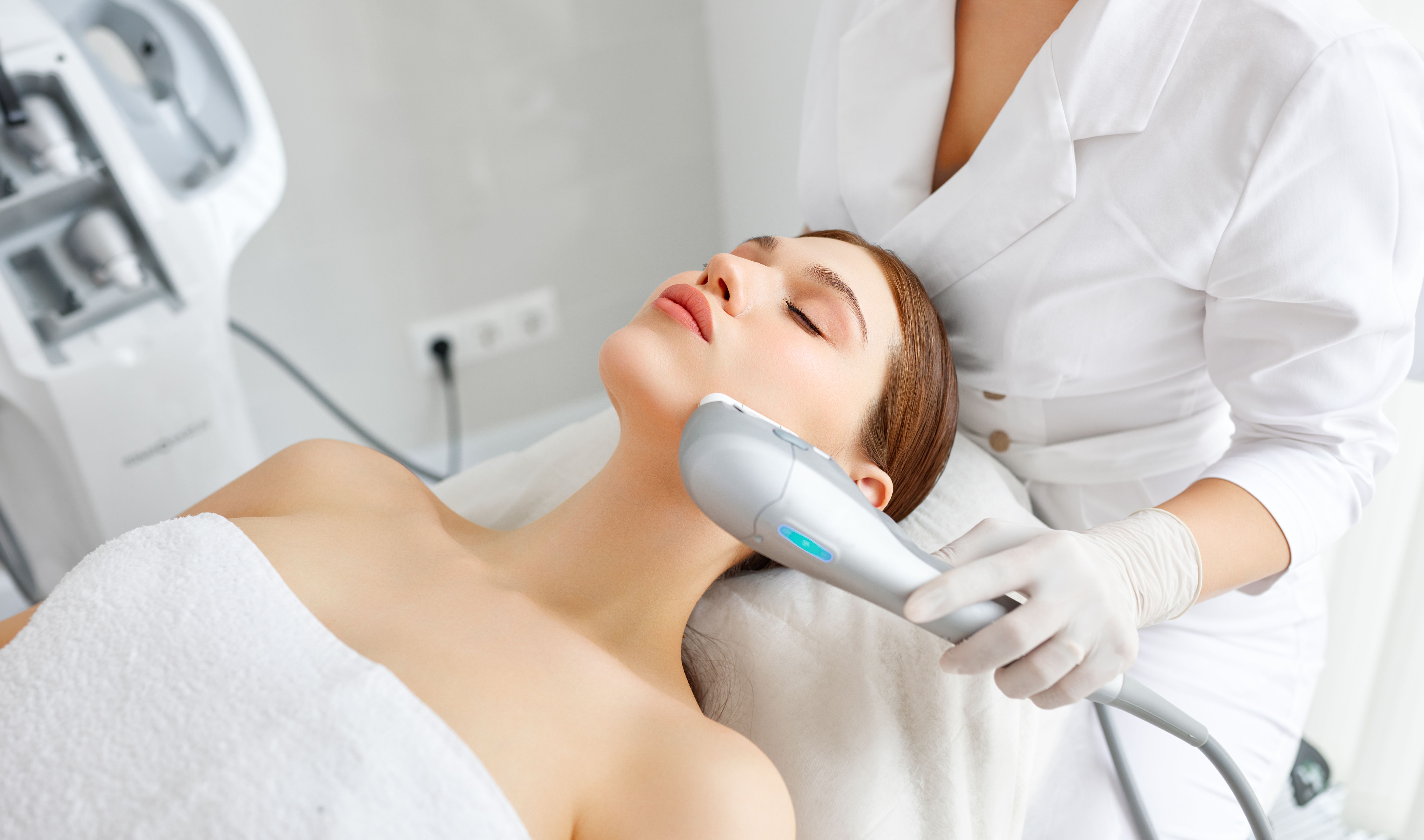 Woman getting facial lifting therapy in beauty salon