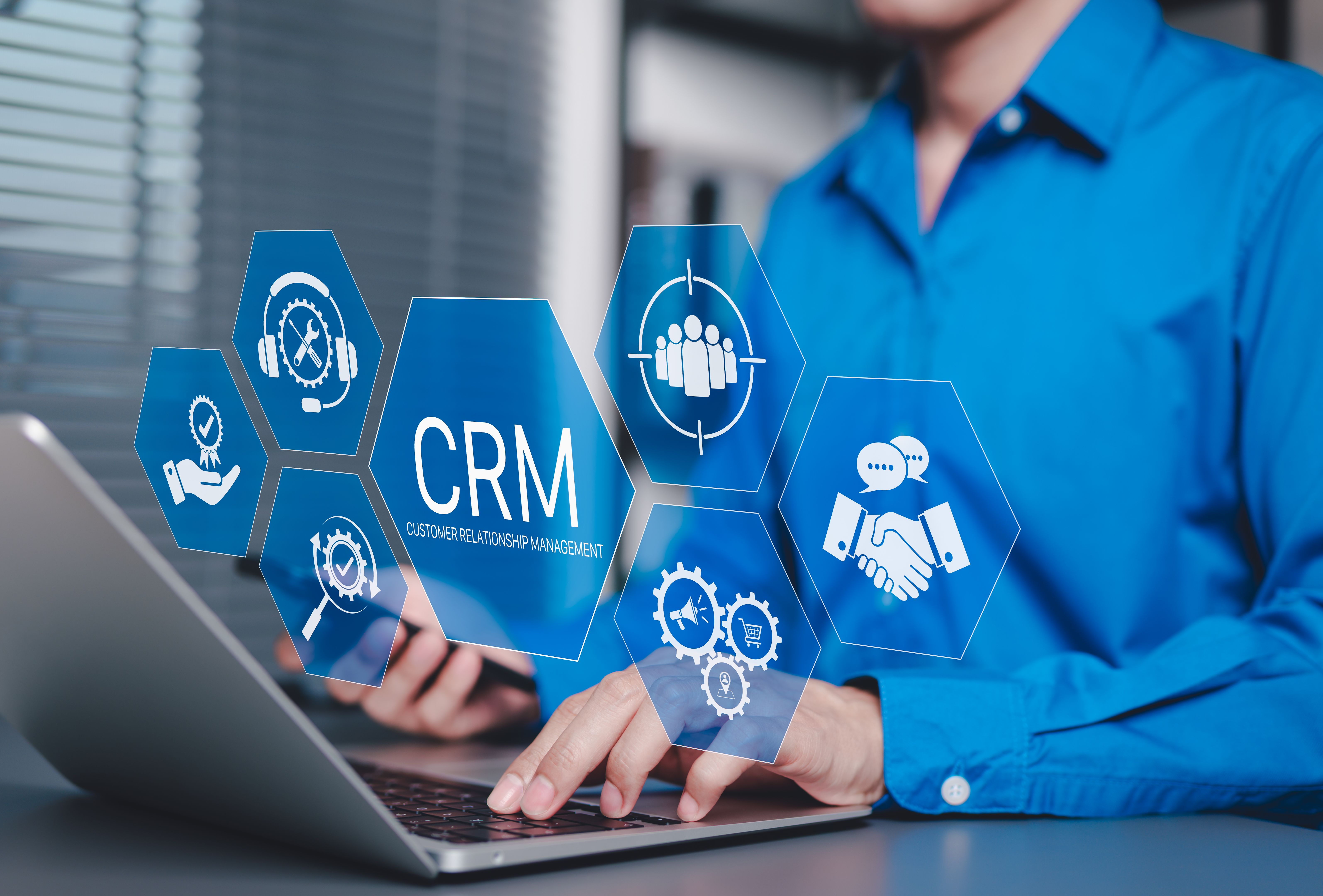 CRM Customer Relationship Management Concept. Businessman using laptop with CRM icons representing customer support, service, relationship building, sales, and marketing automation tools software.