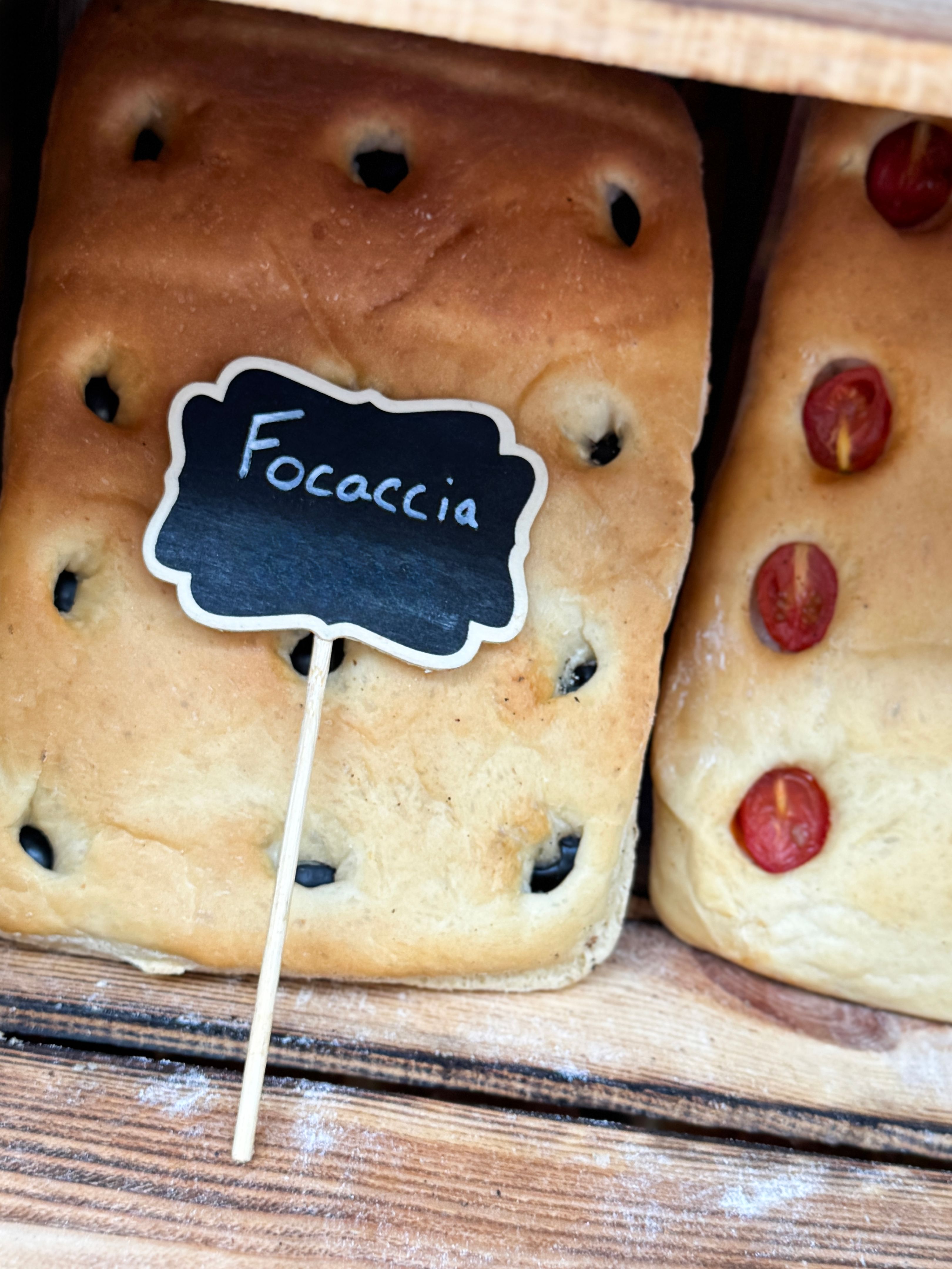 Image of Italian focaccia loaf at bakery / freshly baked bread with golden crust / deliciously soft and fluffy interior