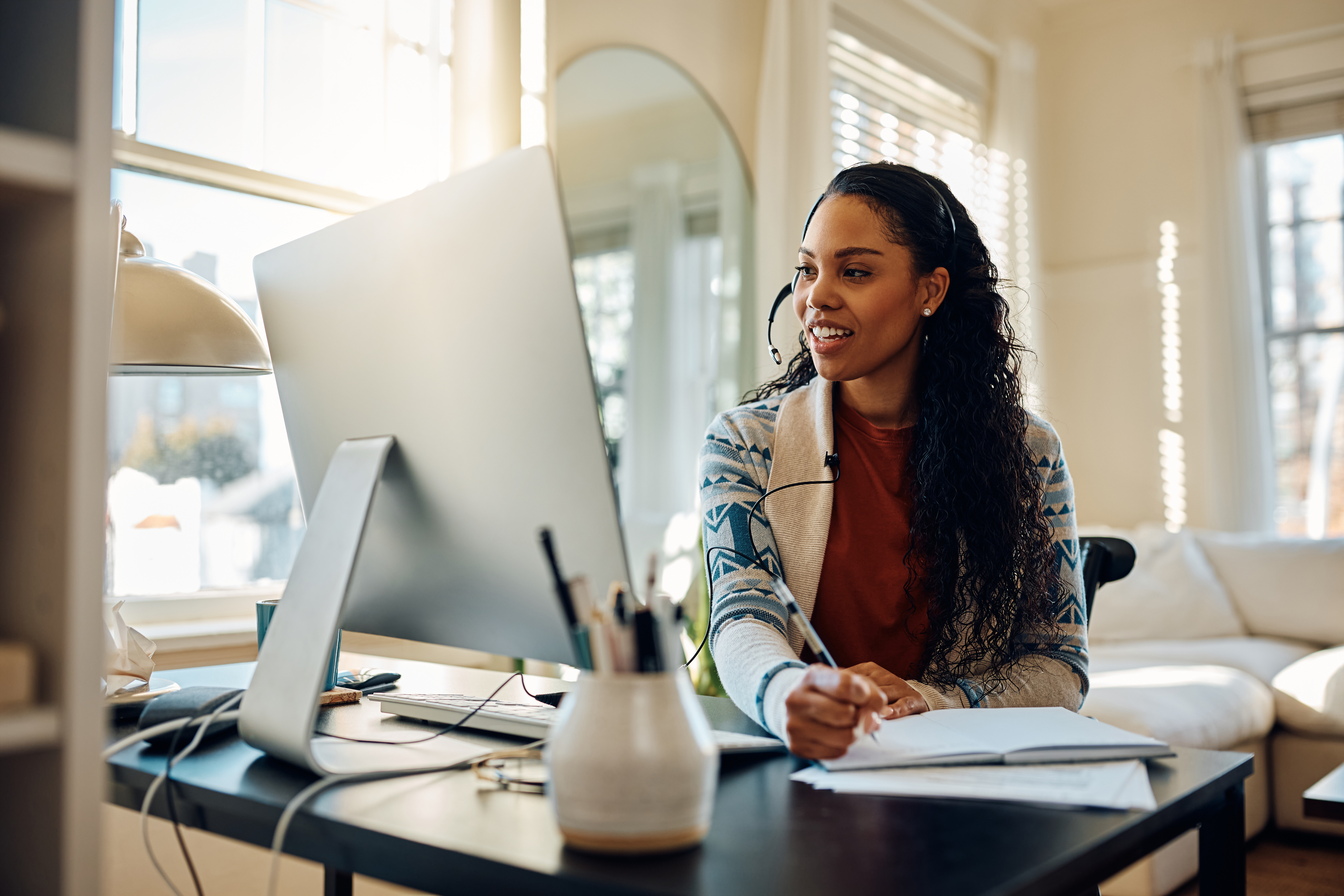 Happy African American female student having video call while e-learning at home. Happy African American female student having video call while e-learning at home.