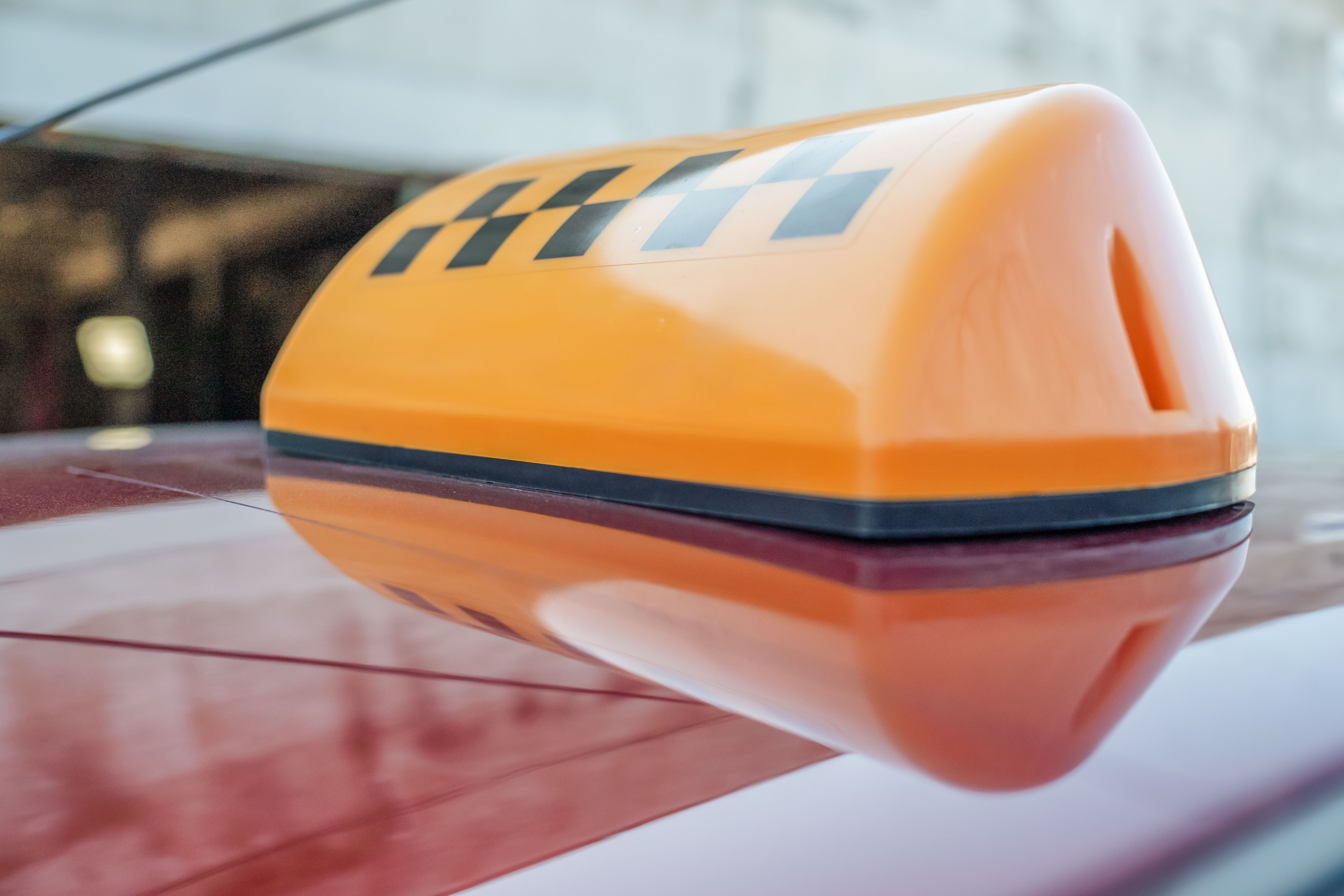 Light box bright yellow with checkers on the roof of a taxi close-up