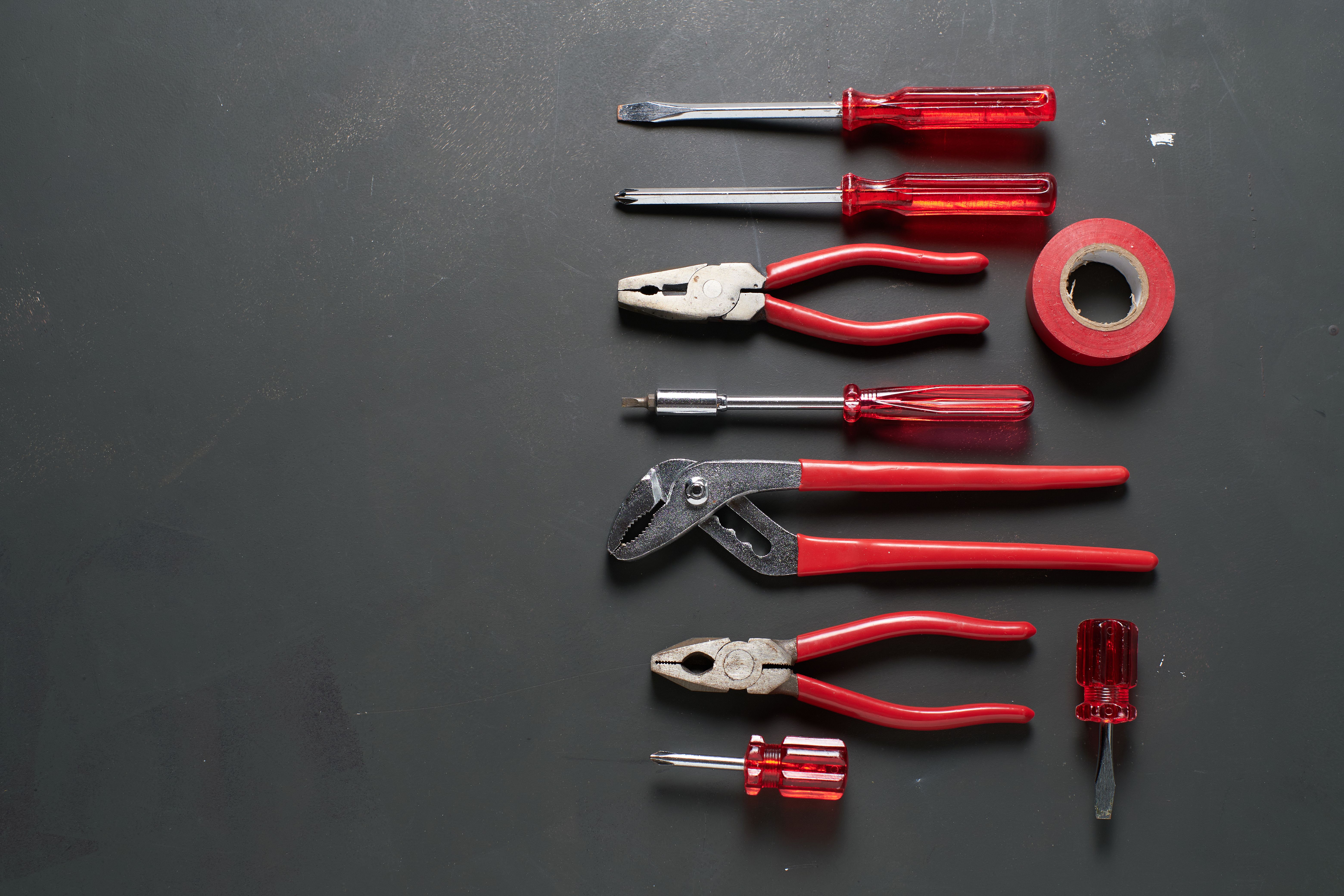 Tools organized neatly on a dark surface in a workshop setting for repair tasks