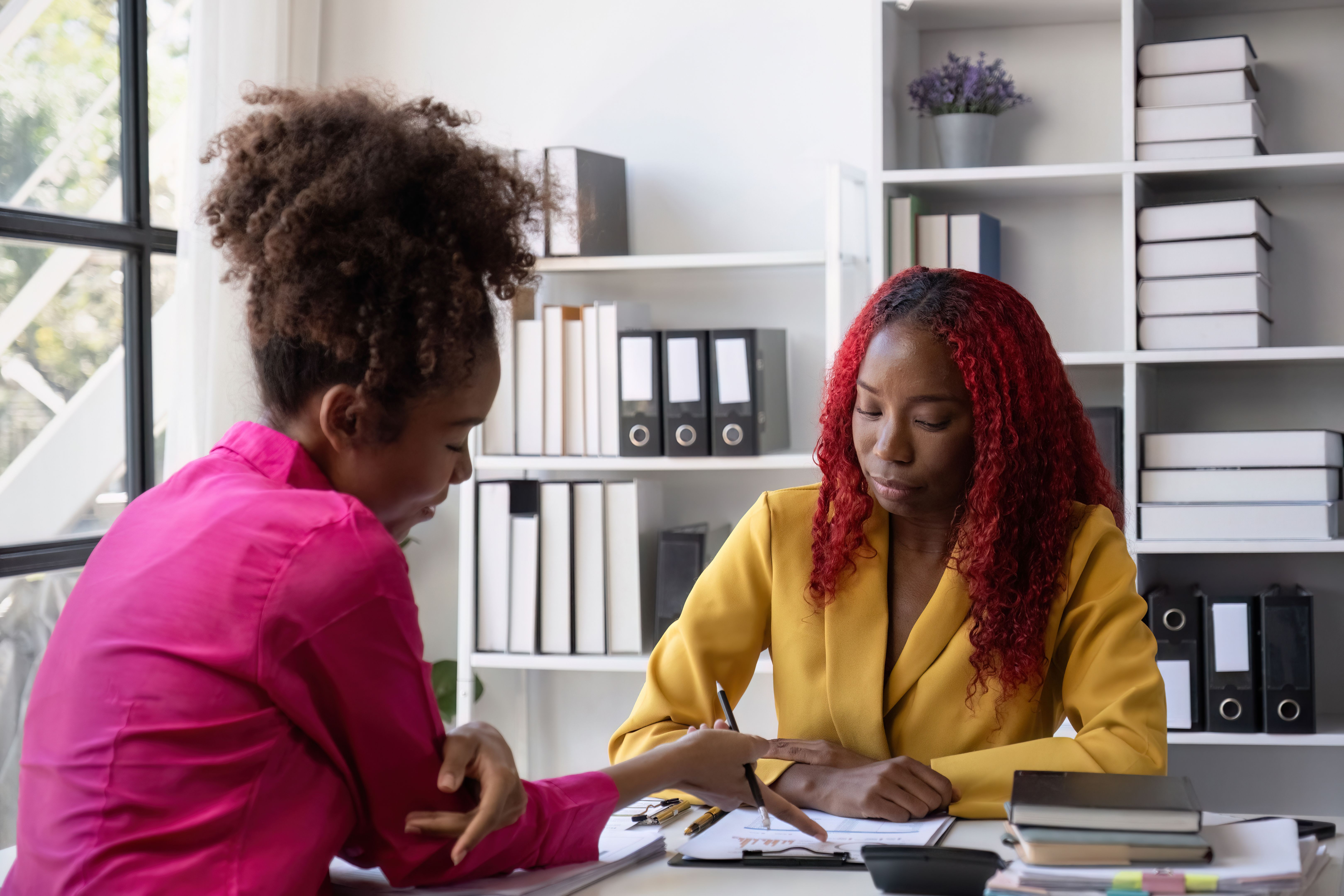 Young African American Business Woman Stressed with Paperwork in Modern Office Setting, Discussing with Colleague