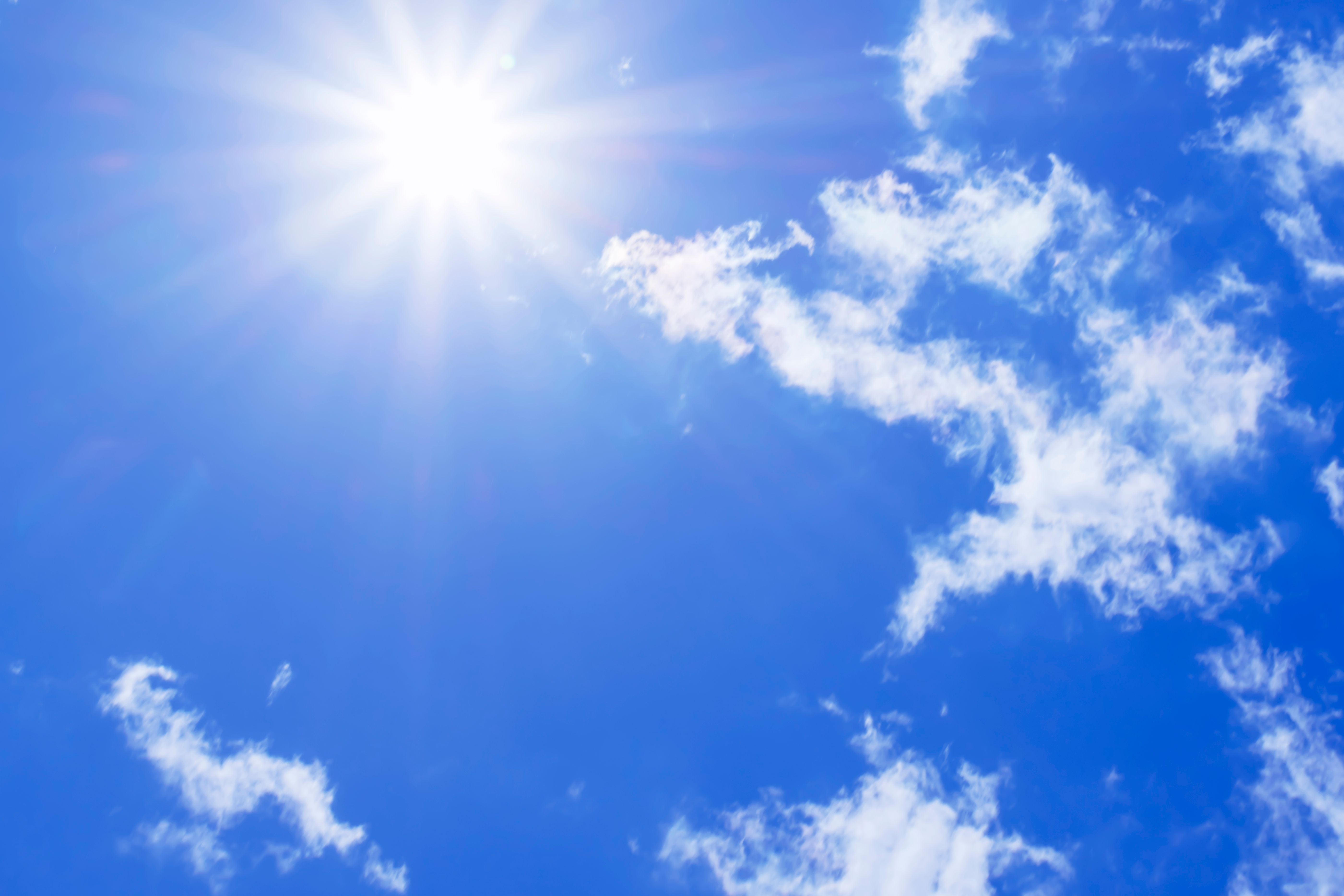 Bright sun with beautiful beams in the sky with light clouds Bright sun with beautiful beams in the sky with light clouds